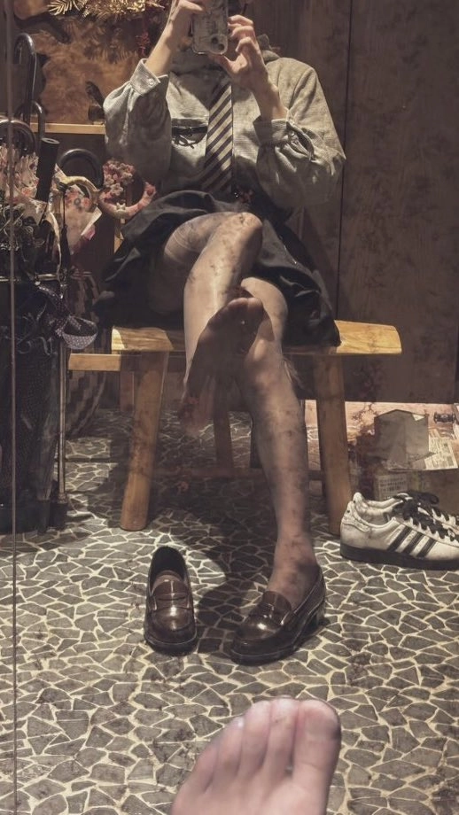 女人坐在椅子上,脚抬起来。