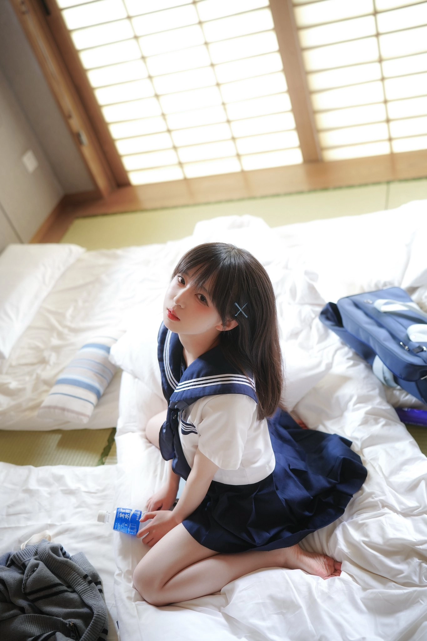 穿着蓝色和白色衣服的女人坐在床上。