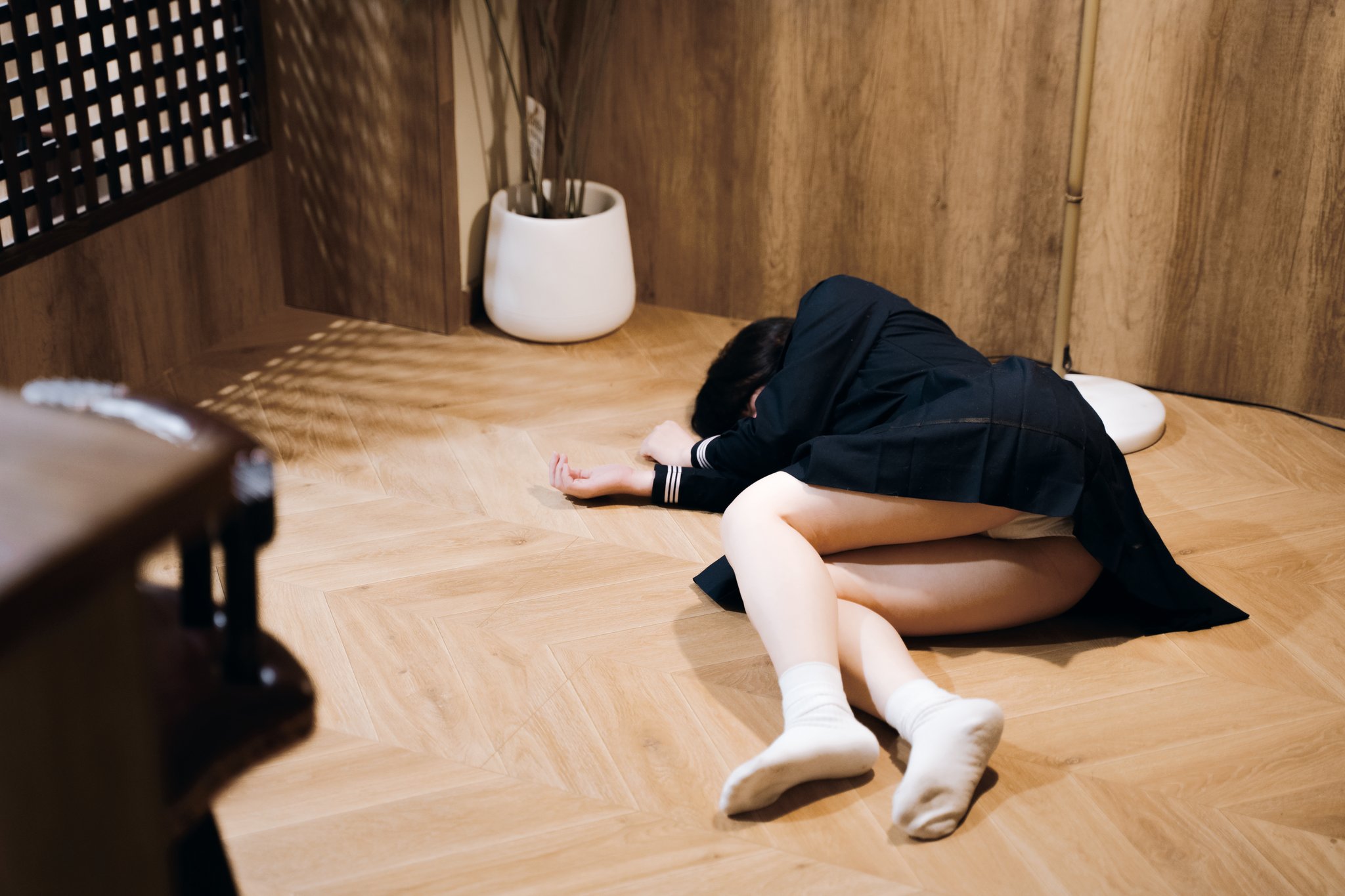 穿着黑色夹克的女人躺在地板上。