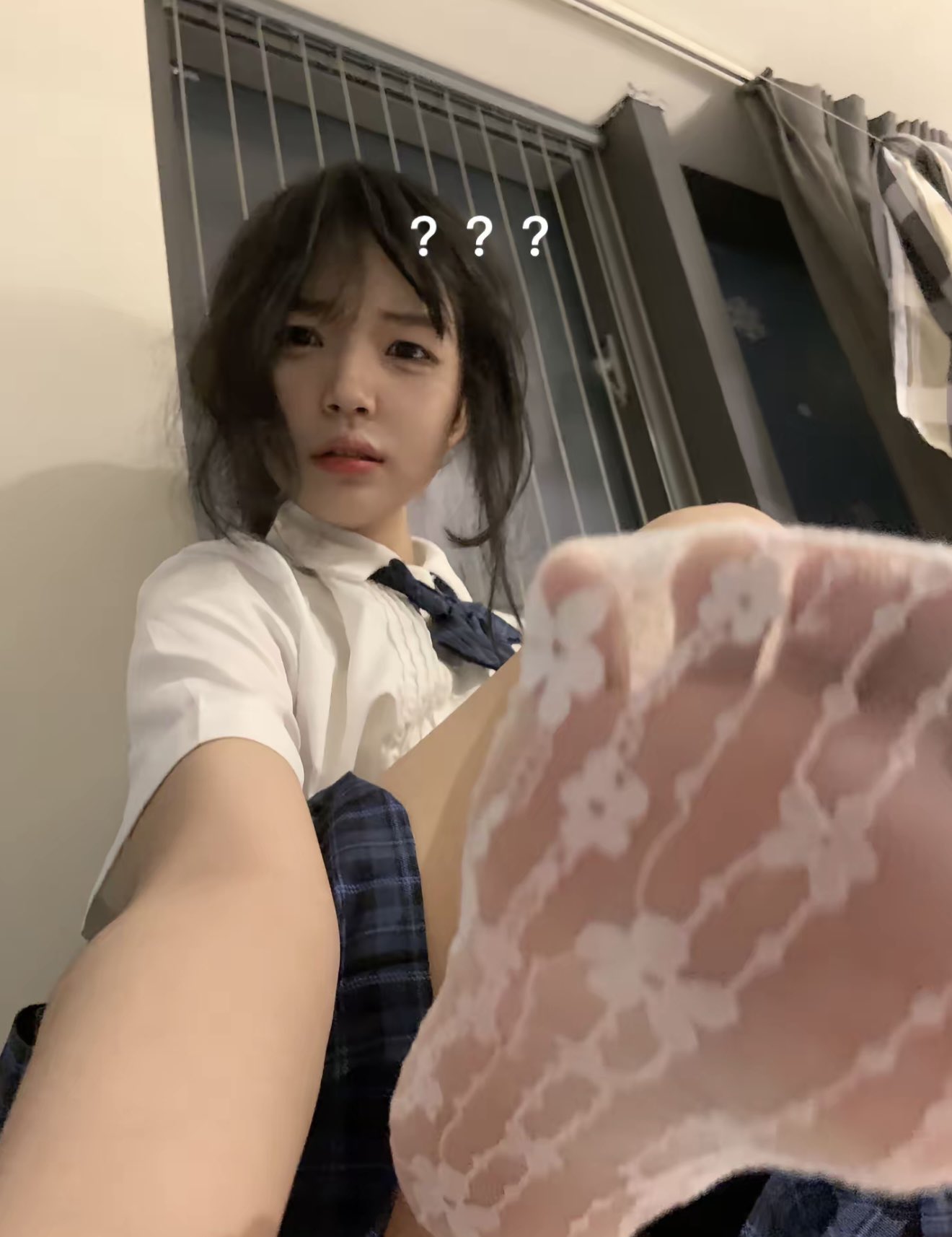 头发上有蓝弓的女孩坐在地板上。