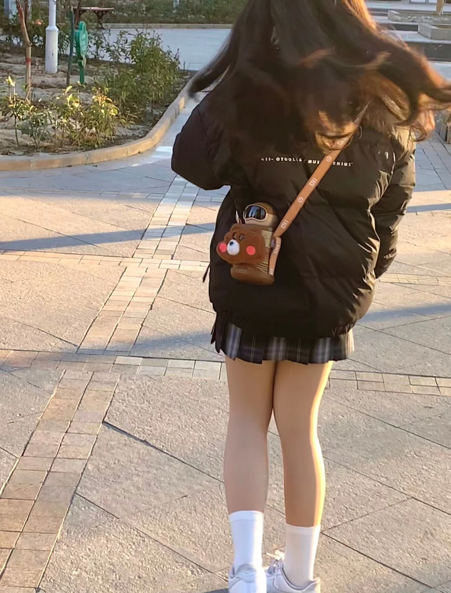 女人穿着黑色夹克,带着一个钱包。