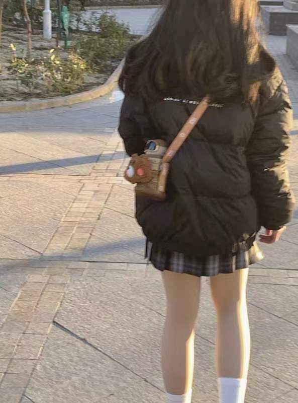 女人穿着黑色夹克,带着一个钱包。