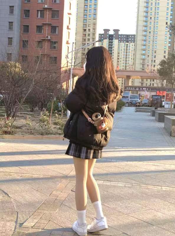 女人穿着黑色夹克,带着一个钱包。