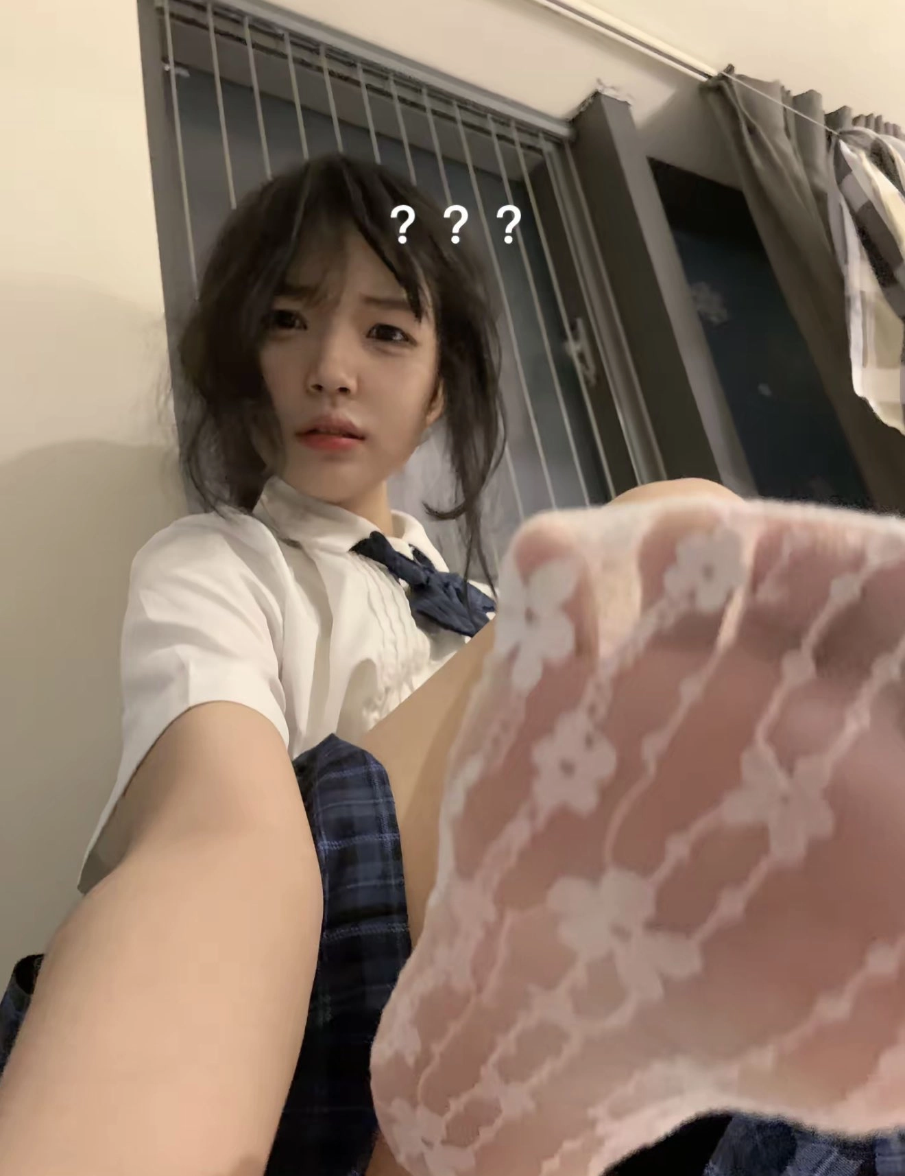 头发上有蓝弓的女孩坐在地板上。