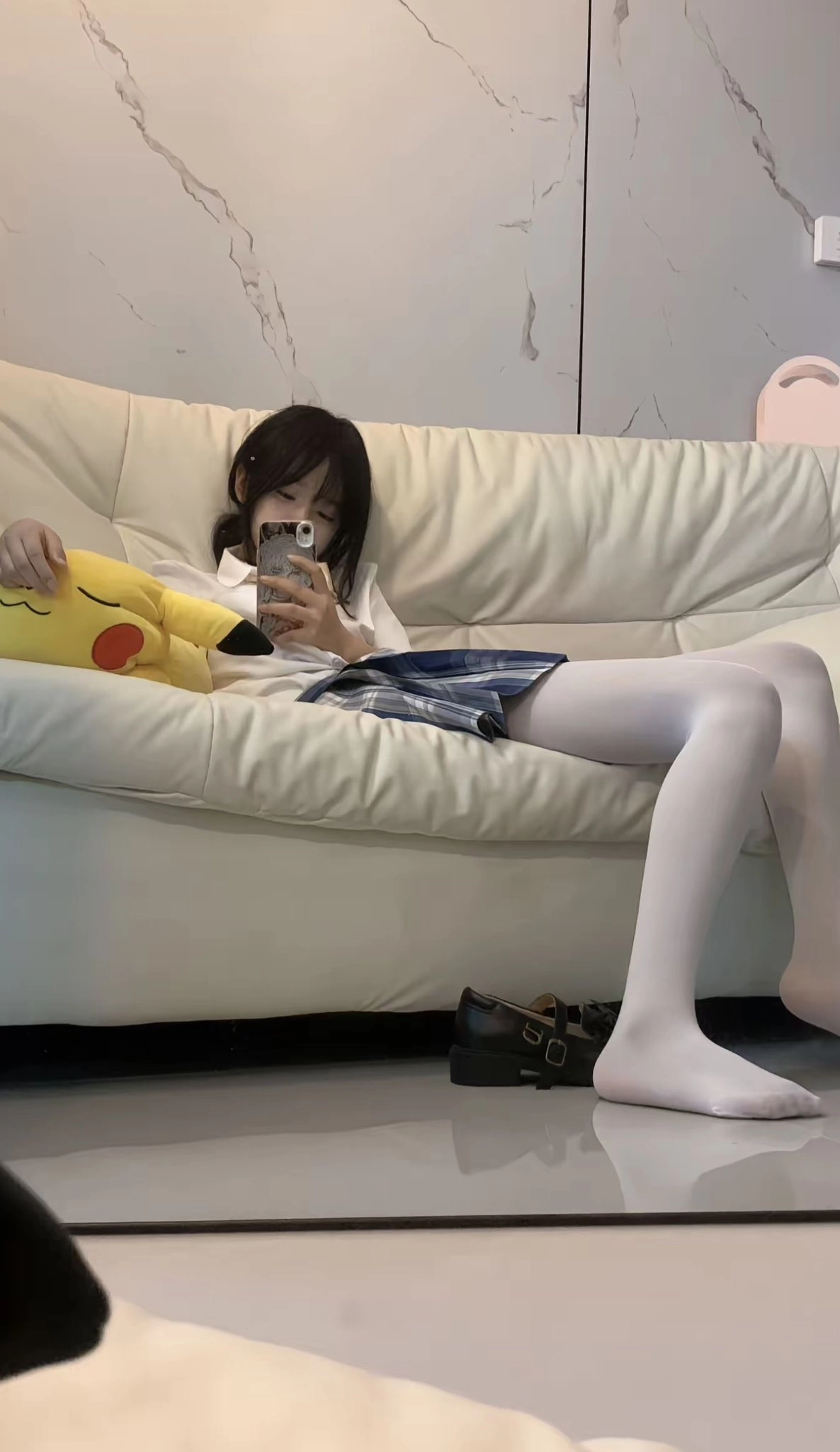 女孩躺在沙发上,看着她的手机。