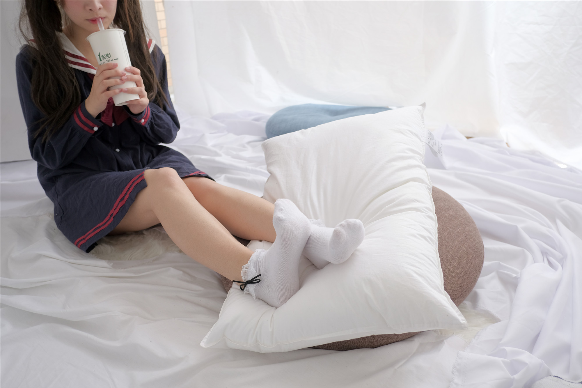 穿蓝色衬衫和白色袜子的女人坐在床上。