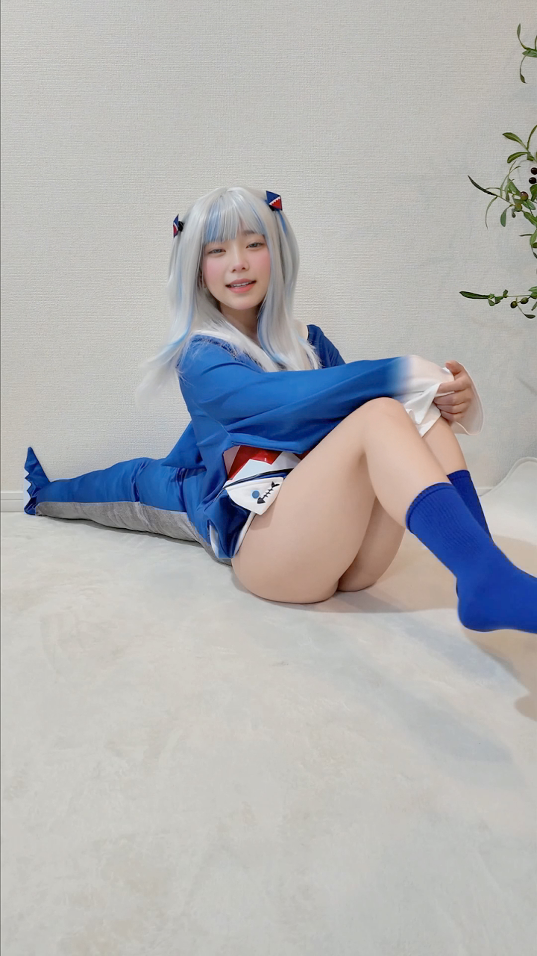 穿着蓝色和白色衣服的女孩坐在地板上。