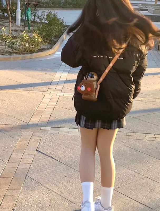 女人穿着黑色夹克,带着一个钱包。