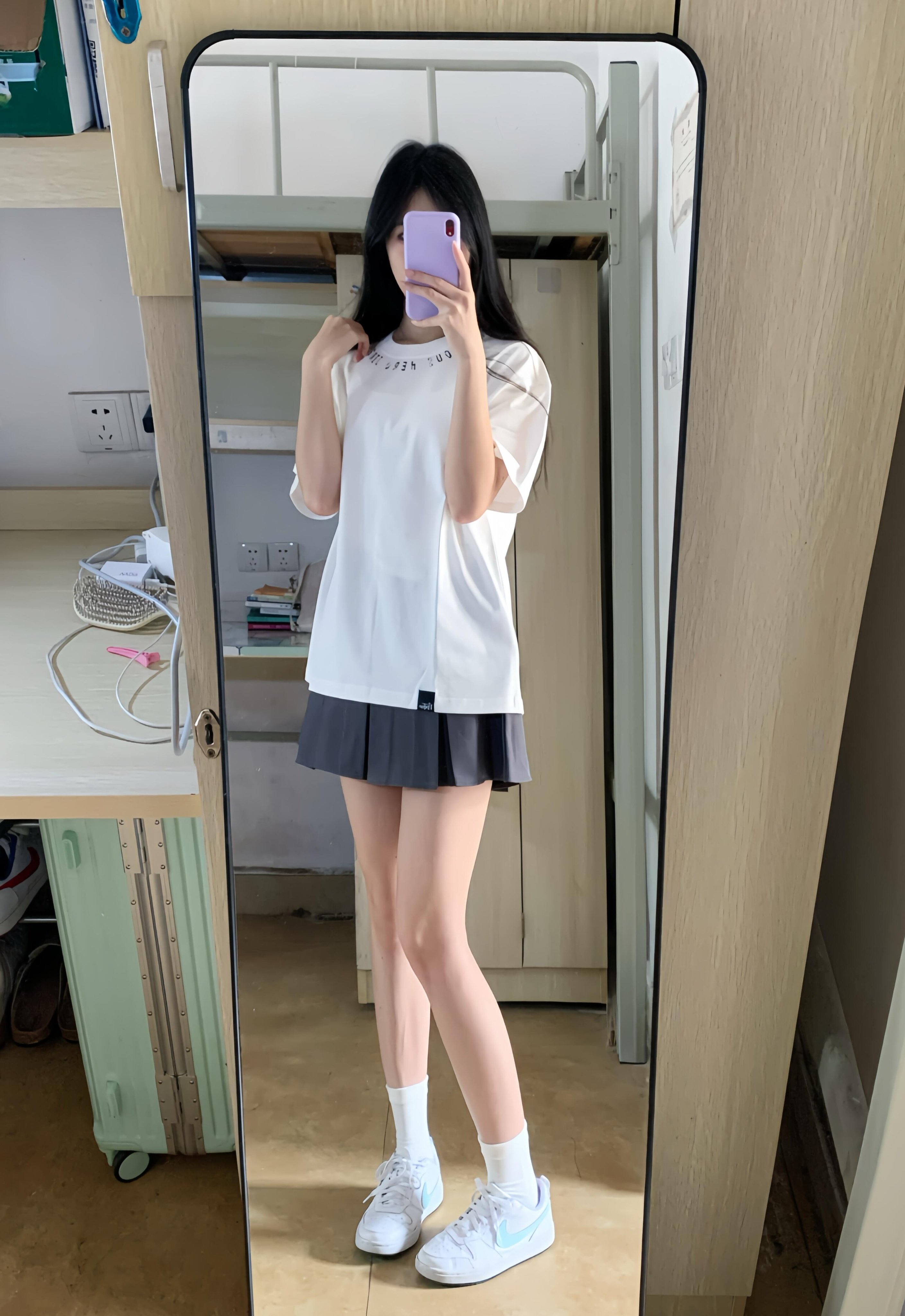 女孩在镜子前拍自拍。