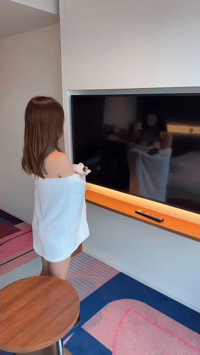 穿着毛巾的女人正在玩视频游戏。