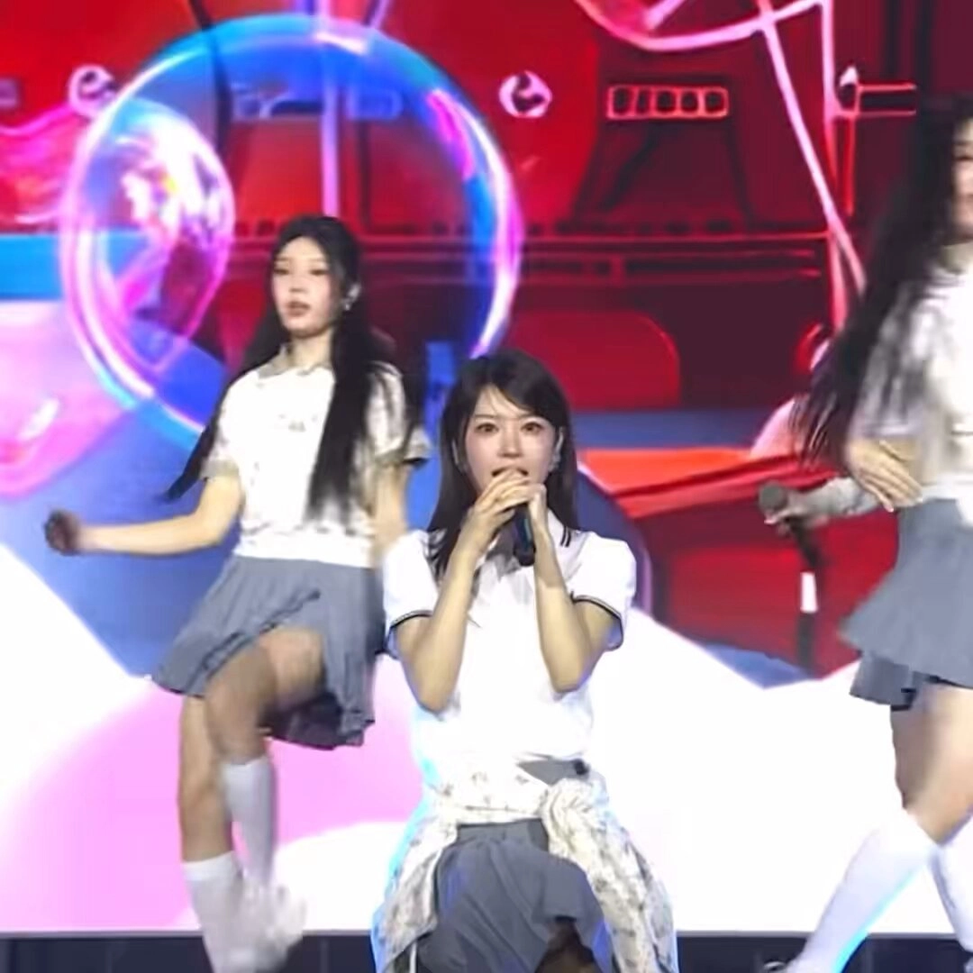 三个女孩在舞台上唱歌。