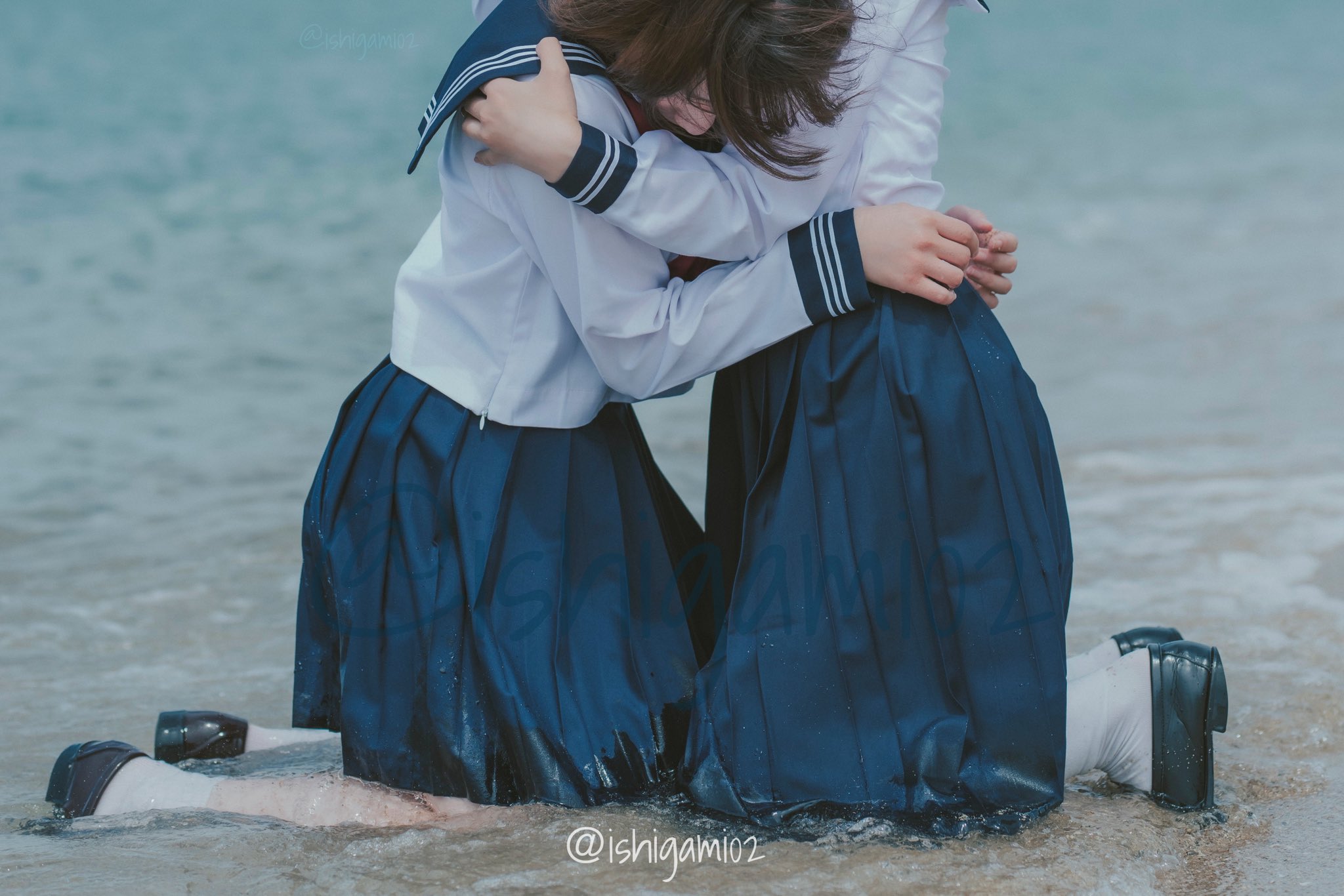 两个女孩在海滩上拥抱。