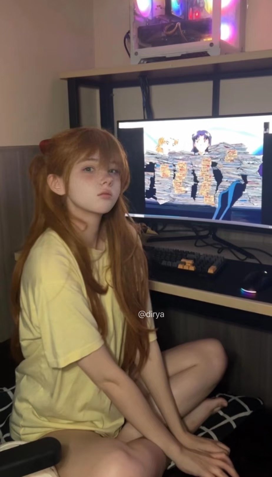 长发的女孩坐在电脑屏幕前。