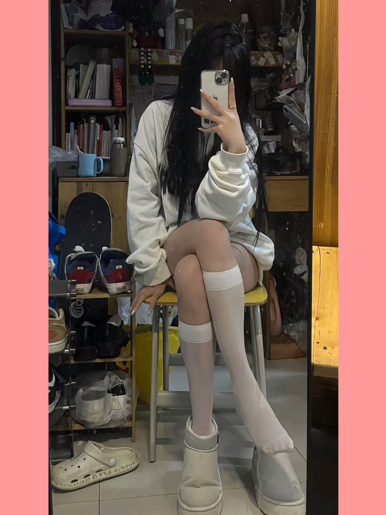 女人在一个房间里拍自拍,带着滑板和书籍。