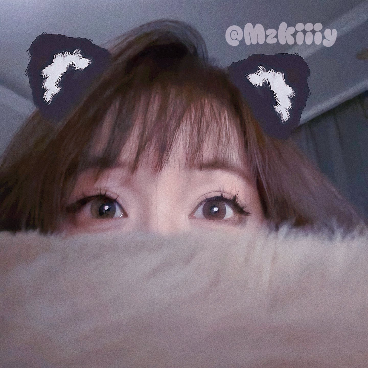 有猫的耳朵的女人从毛皮物体的背后看出来。