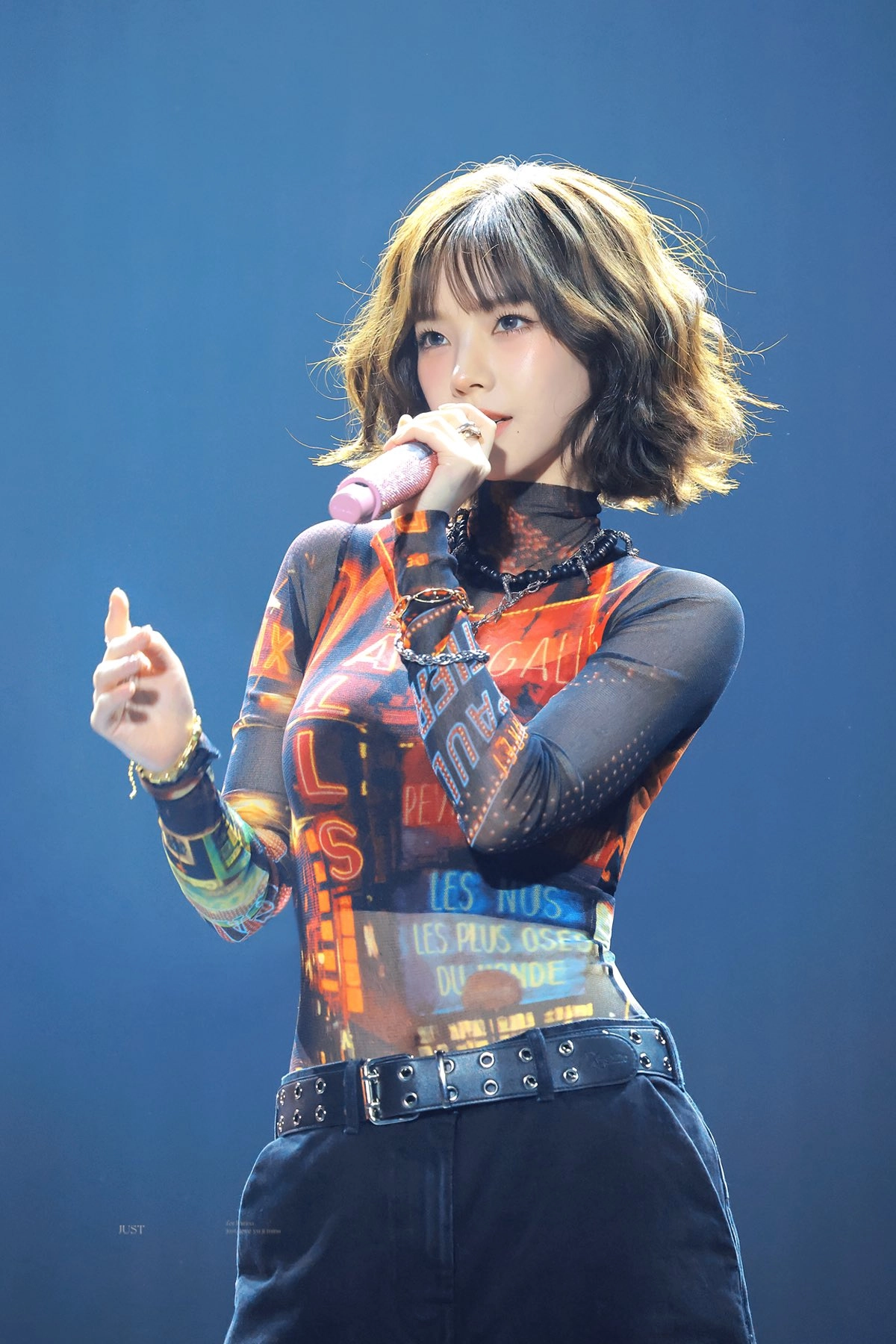 女人穿着黑色衬衫,拿着麦克风。