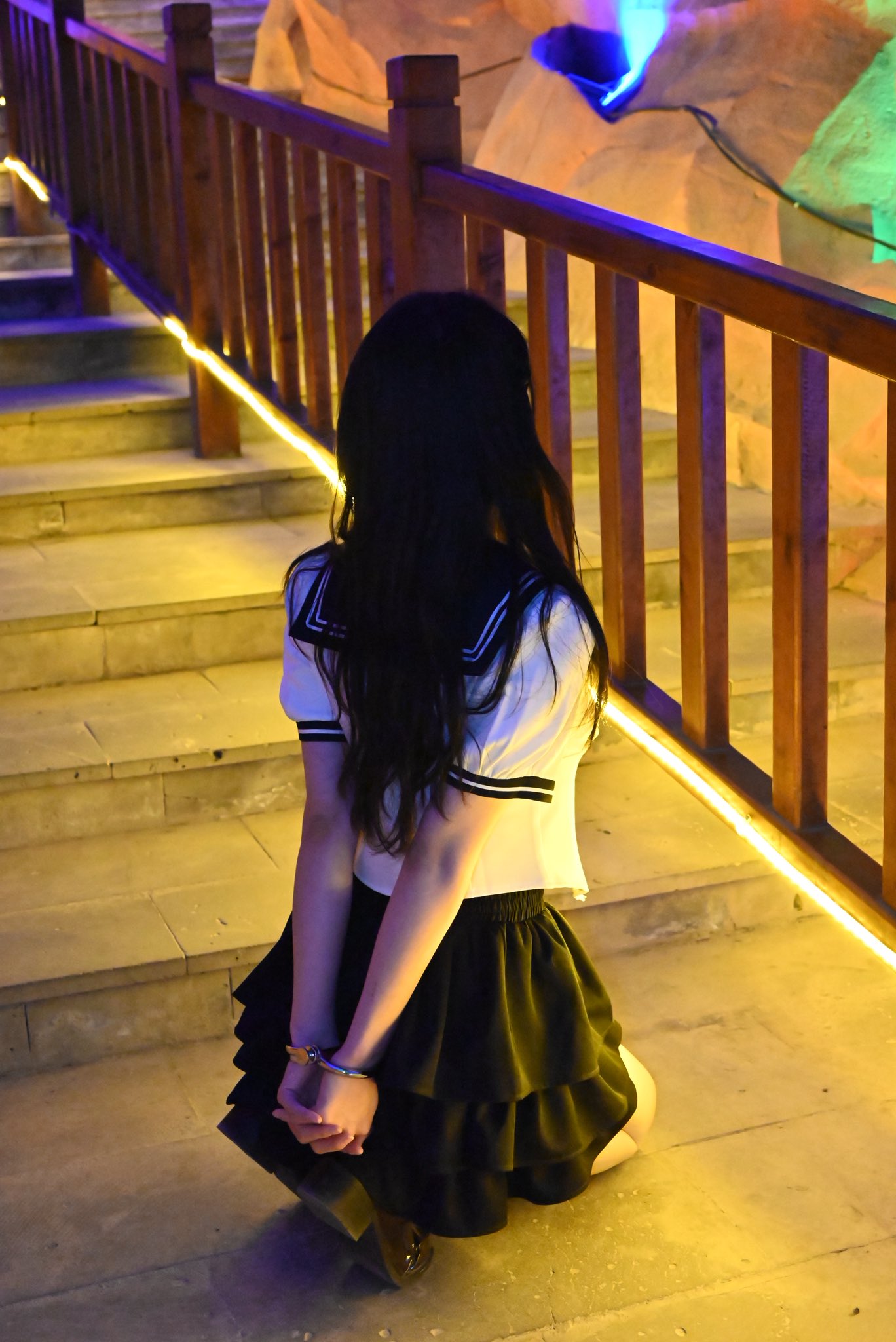 穿着水手服的女人站在楼梯上。