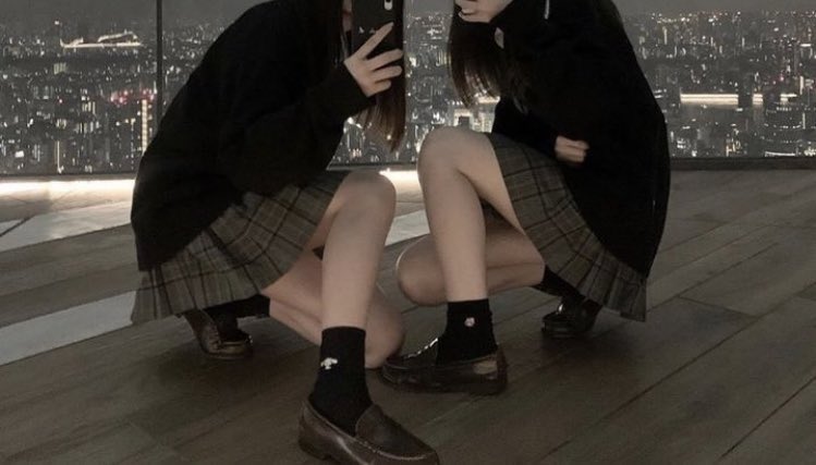 两个女孩在城市天空前拍自拍。