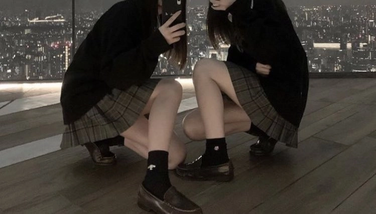 两个女孩在城市天空前拍自拍。