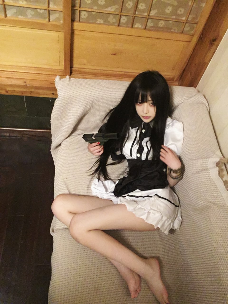 穿着女仆的服装的女人拿着一把枪。