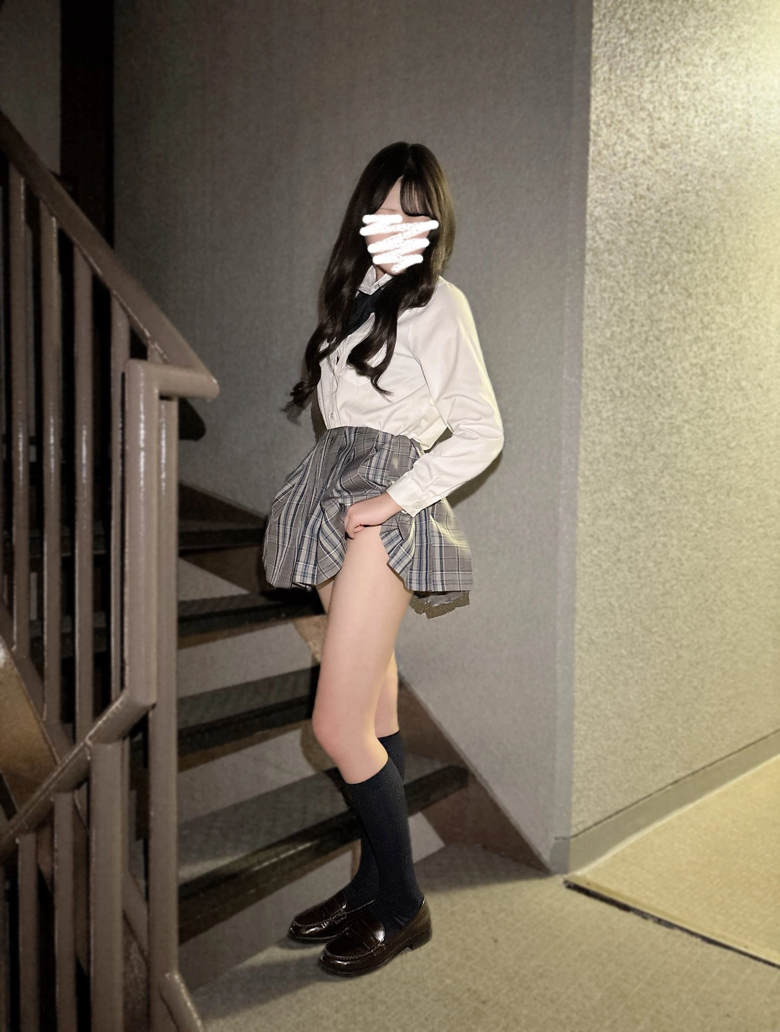 一位戴着裙子和一件白色衬衫的女人站在楼梯上。