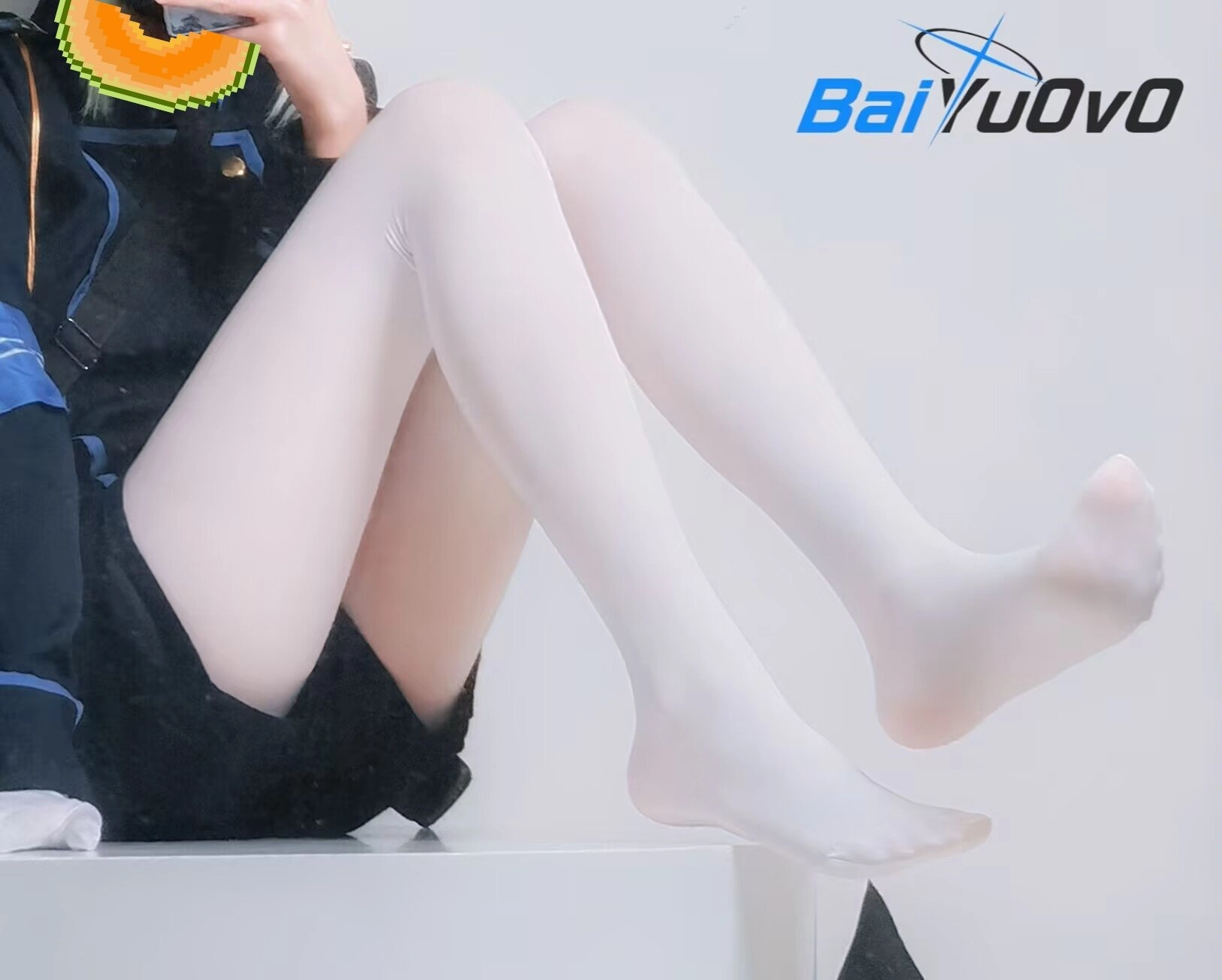 穿着白色衬衫和黑色裙子的女人坐在桌子上。