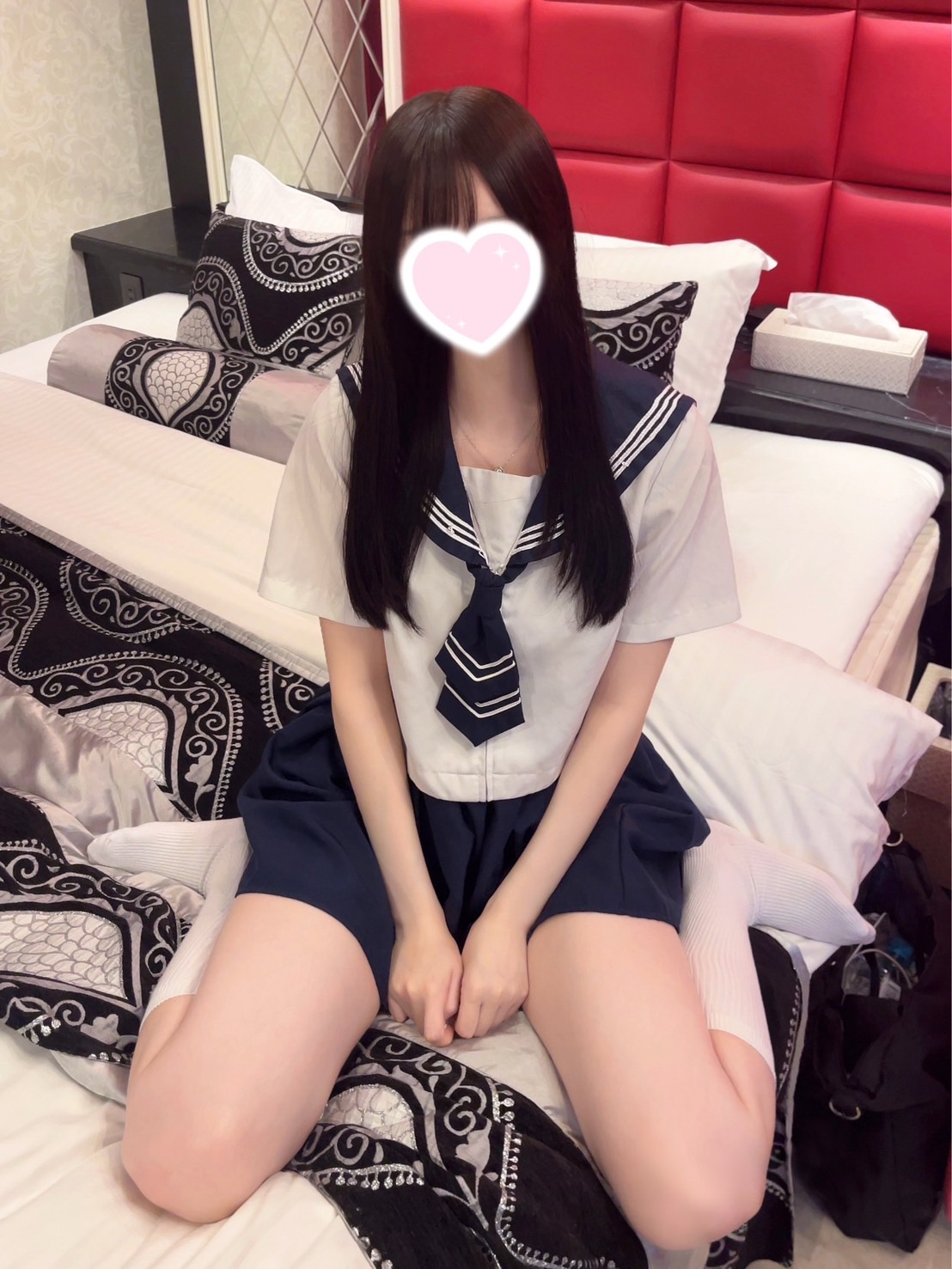 穿着蓝色弓巾的女孩坐在床上。