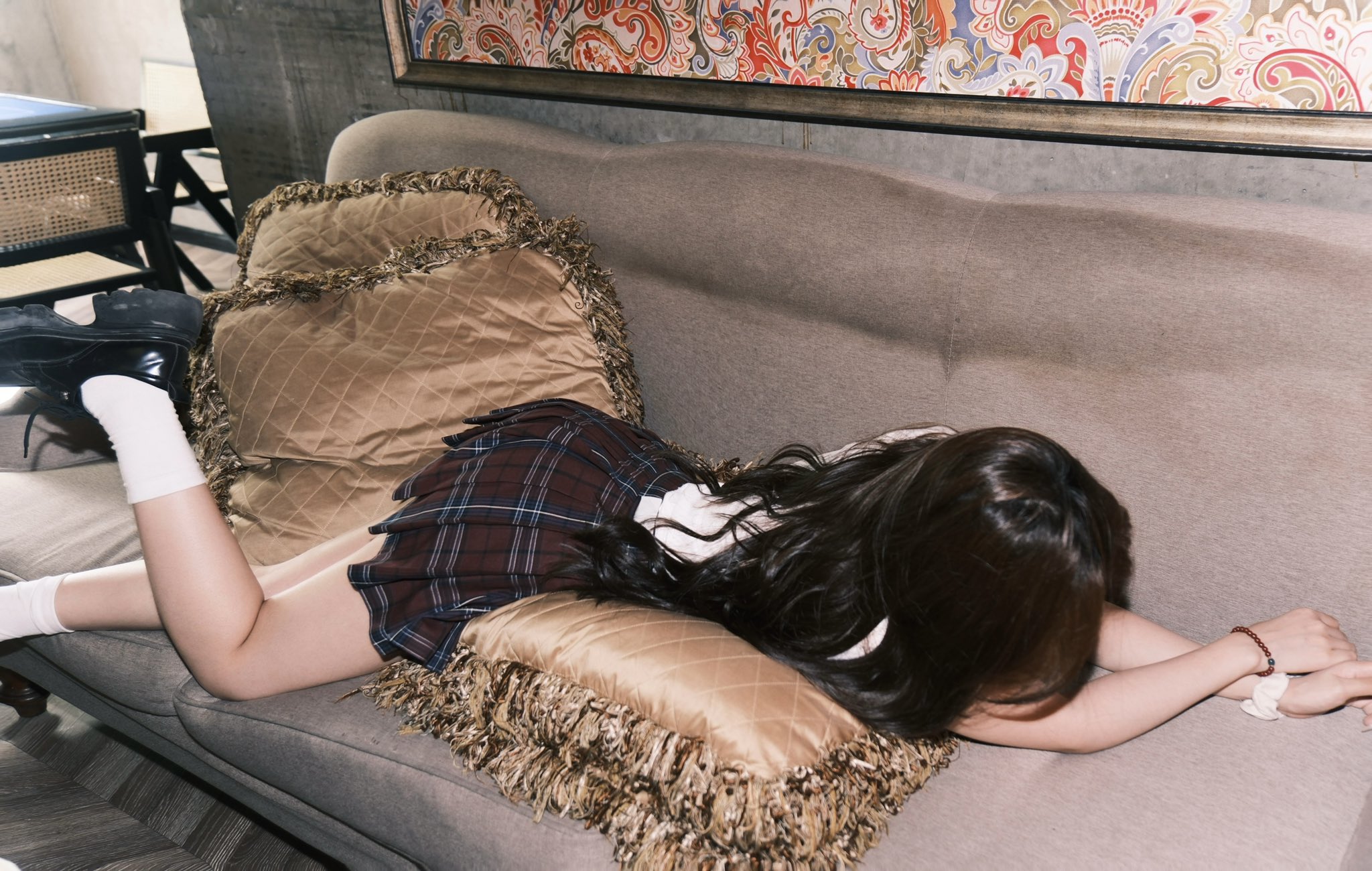 女孩躺在沙发上,戴着枕头。