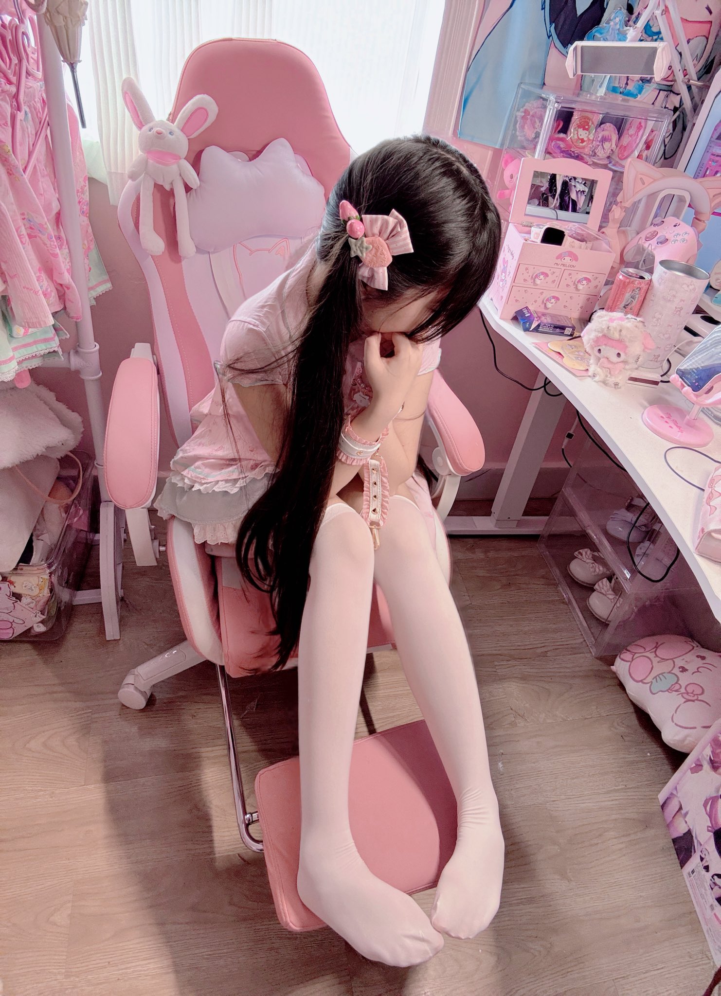 女孩在一个粉红色的椅子上,戴着头发干燥机。