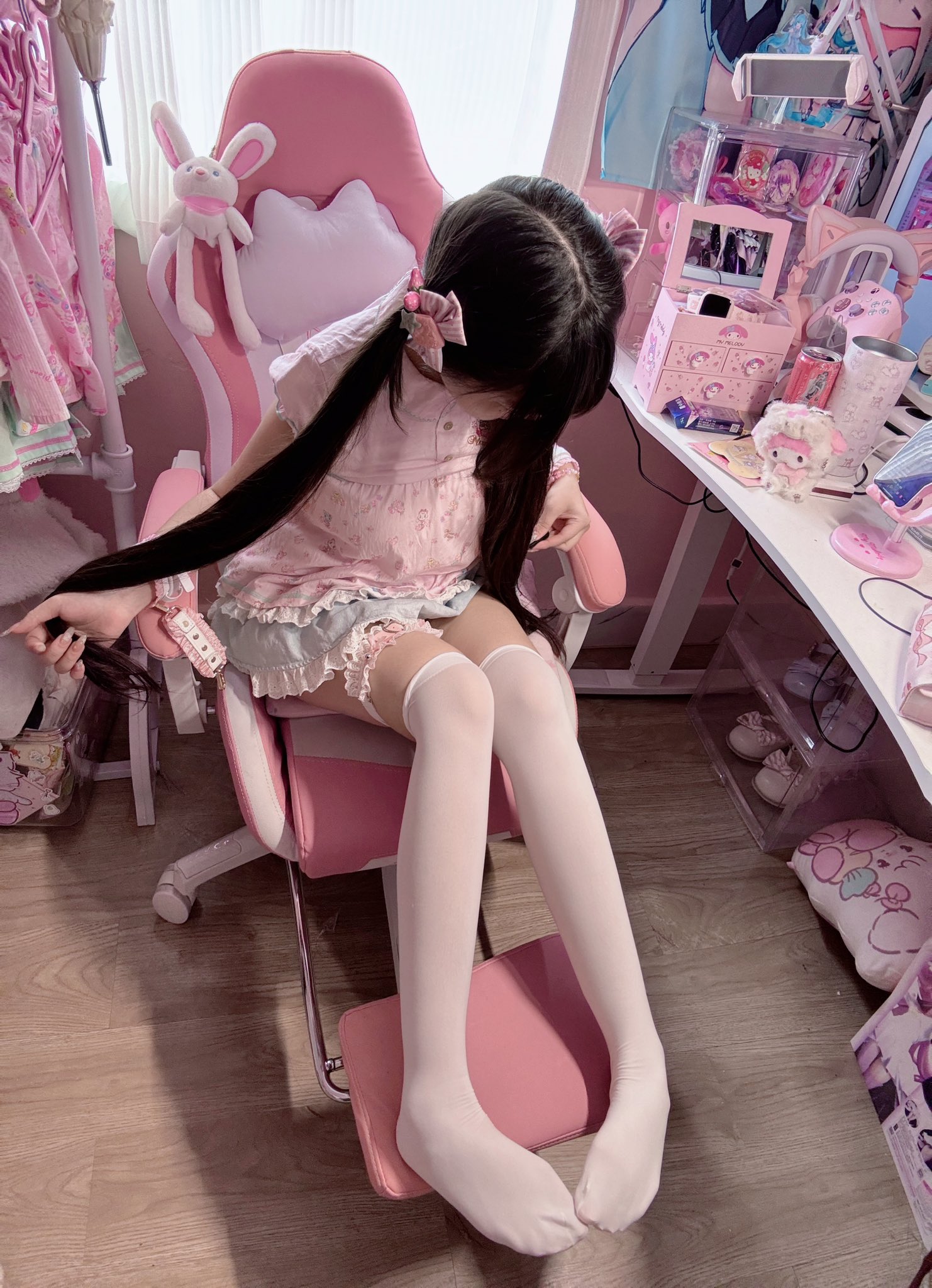 女孩在一个粉红色的椅子上,戴着头发干燥机。