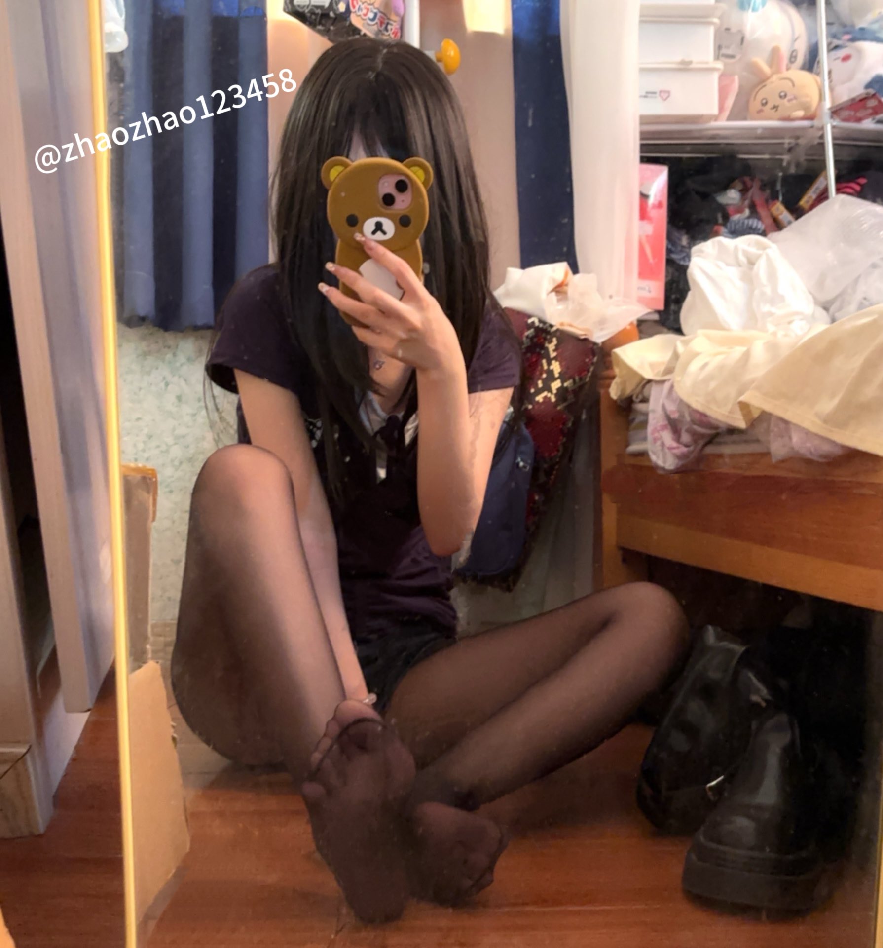 女孩用一只泰迪熊的手机盒拍自拍。