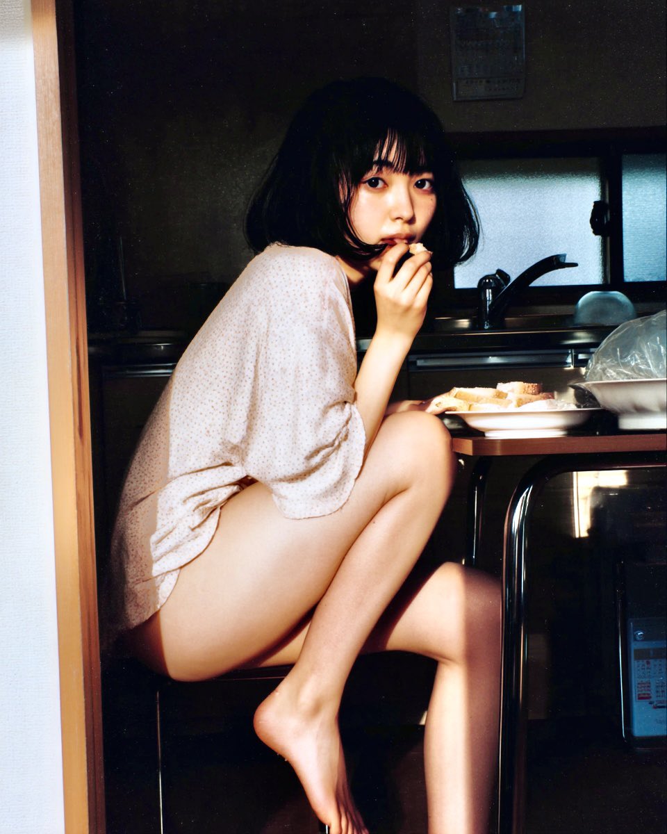 女人在厨房里吃三明治。