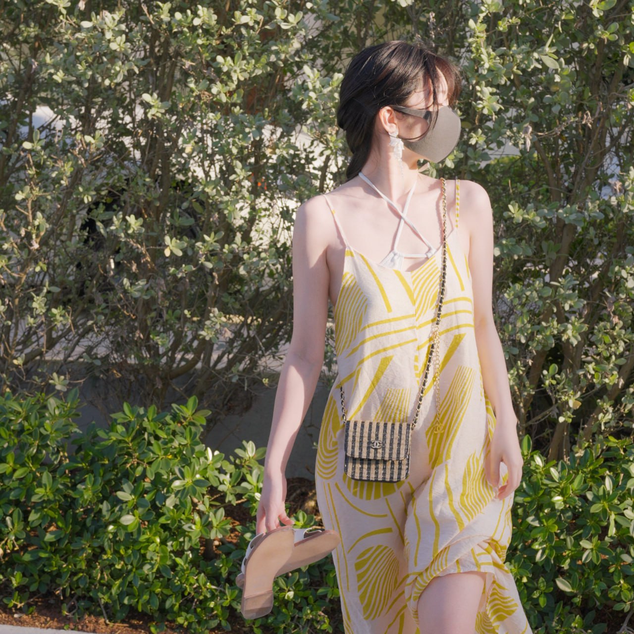 戴着面具的女人在阳光下行走。