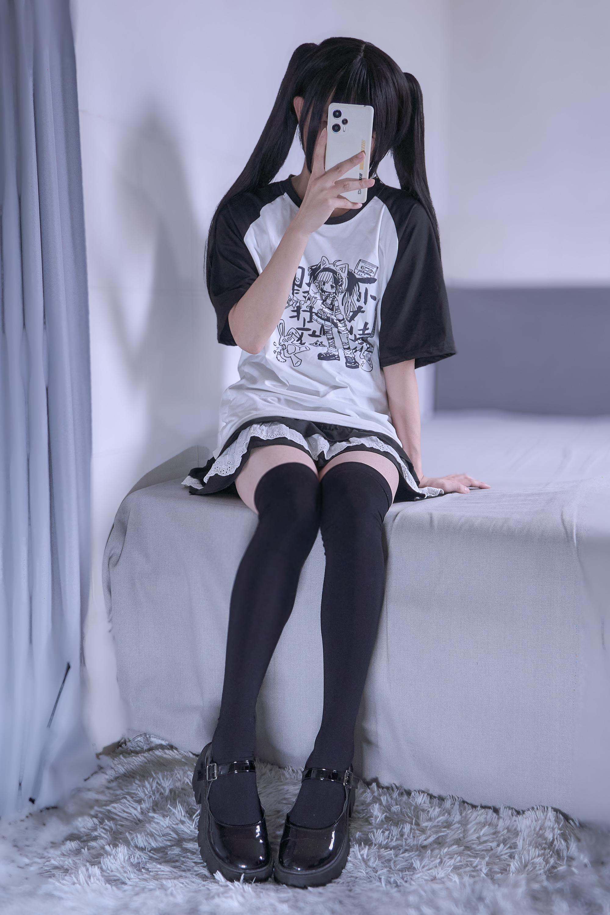 穿着黑色和白色的衬衫和黑色衬衫的女人坐在床上。