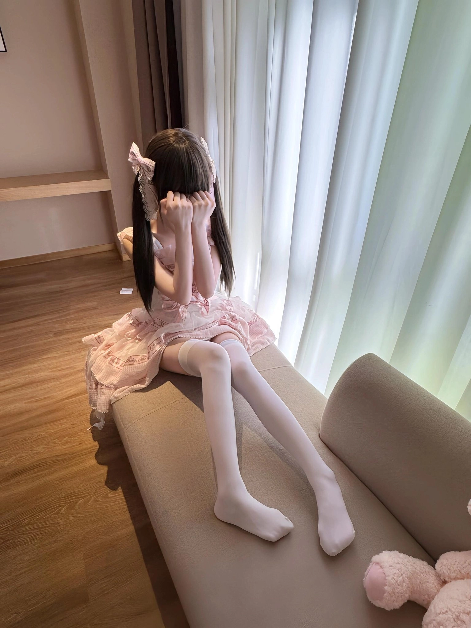 长头发和白袜子的女孩坐在沙发上。