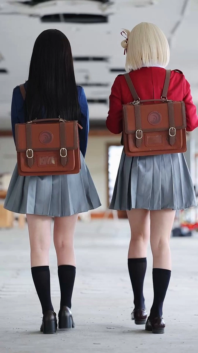 两个女孩穿着棕色和红色的背包。