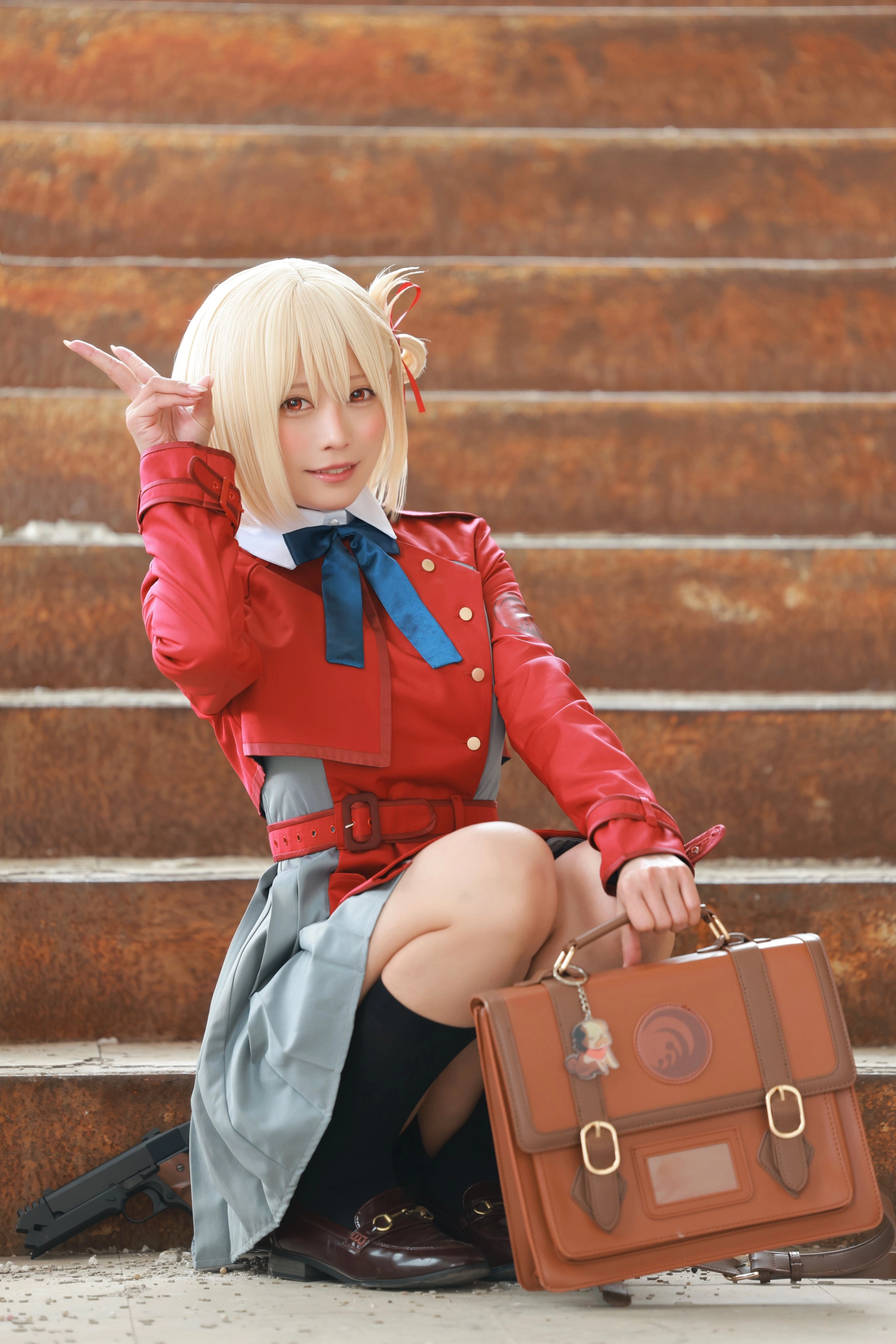 一位穿着红色外套和蓝色弓的女人站在楼梯上。