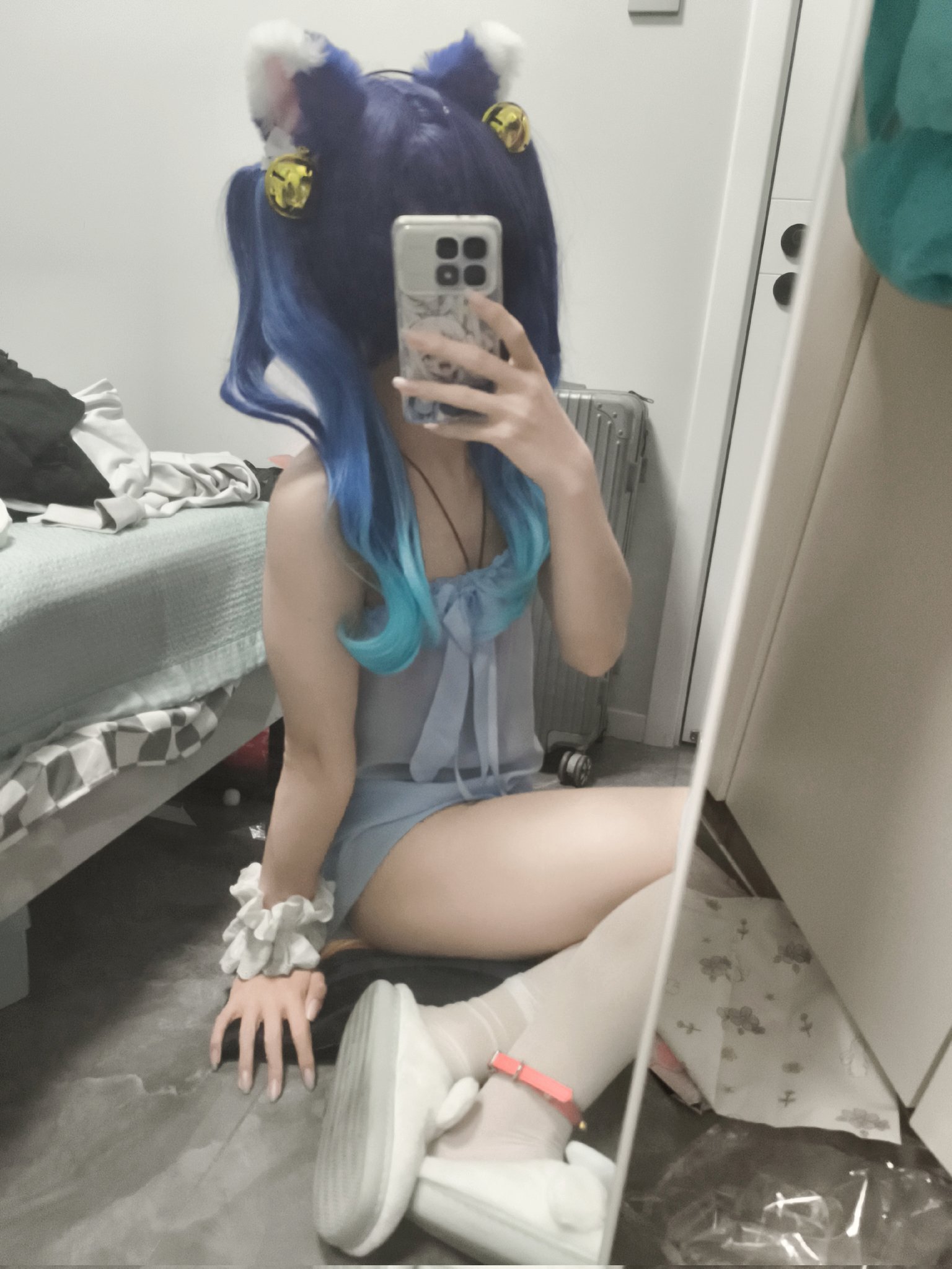 穿着白色袜子和蓝色裙子的人躺在地板上。