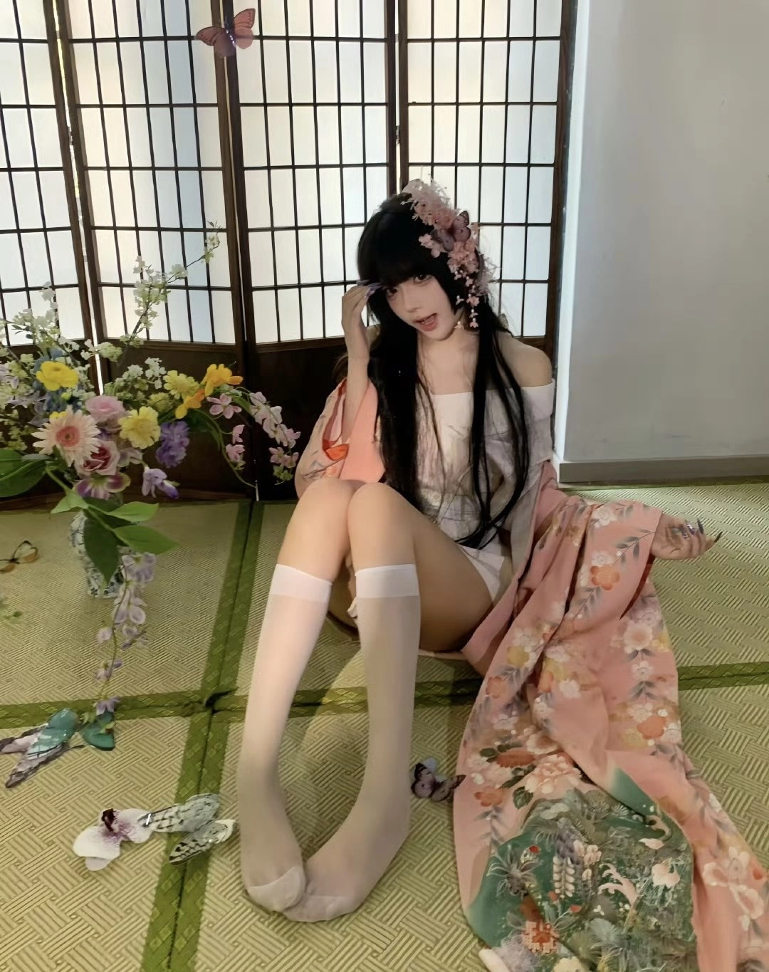 女人穿着一件白色的衣服,头发里有一朵花。