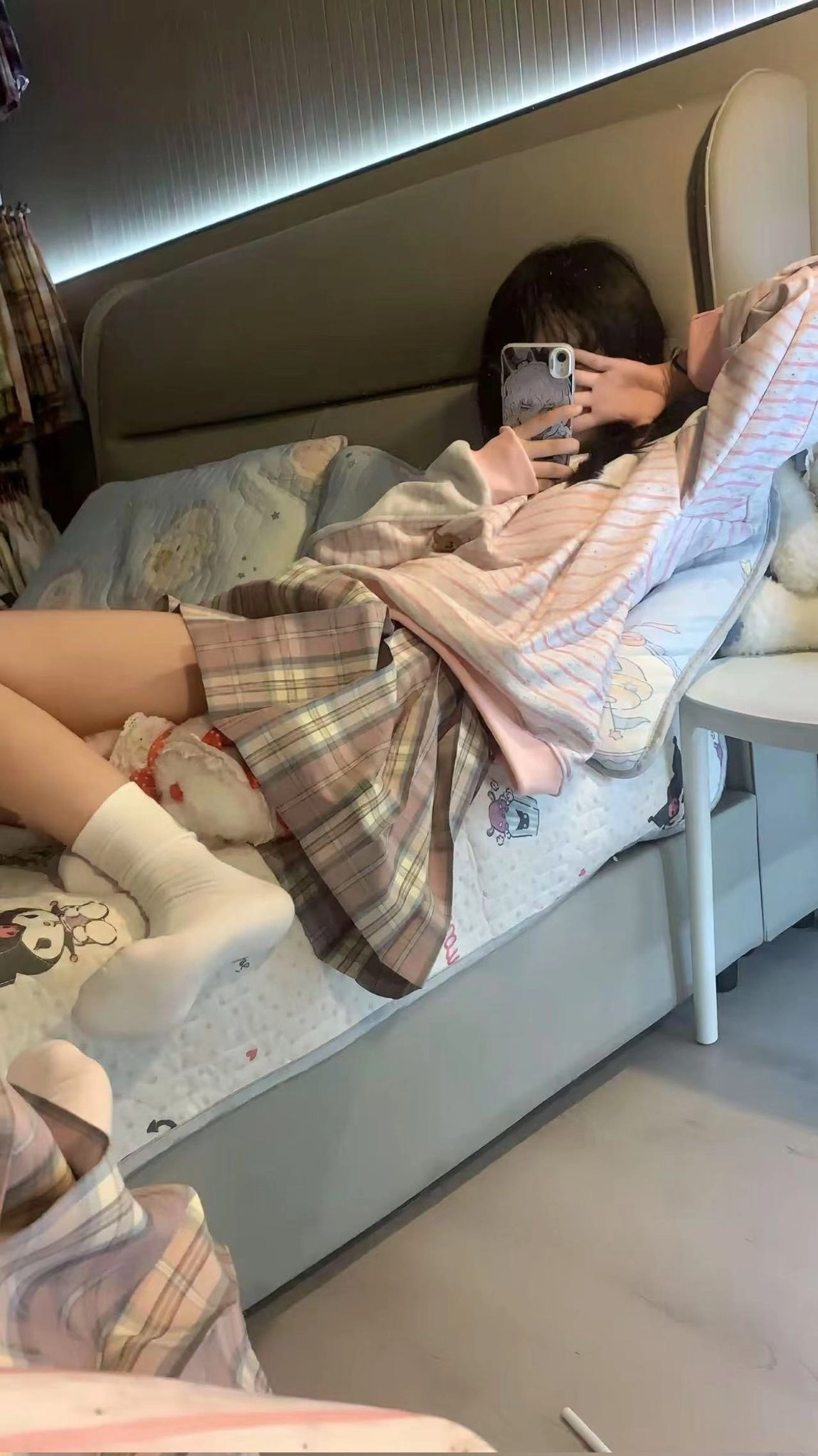 女人躺在床上,拿着手机。