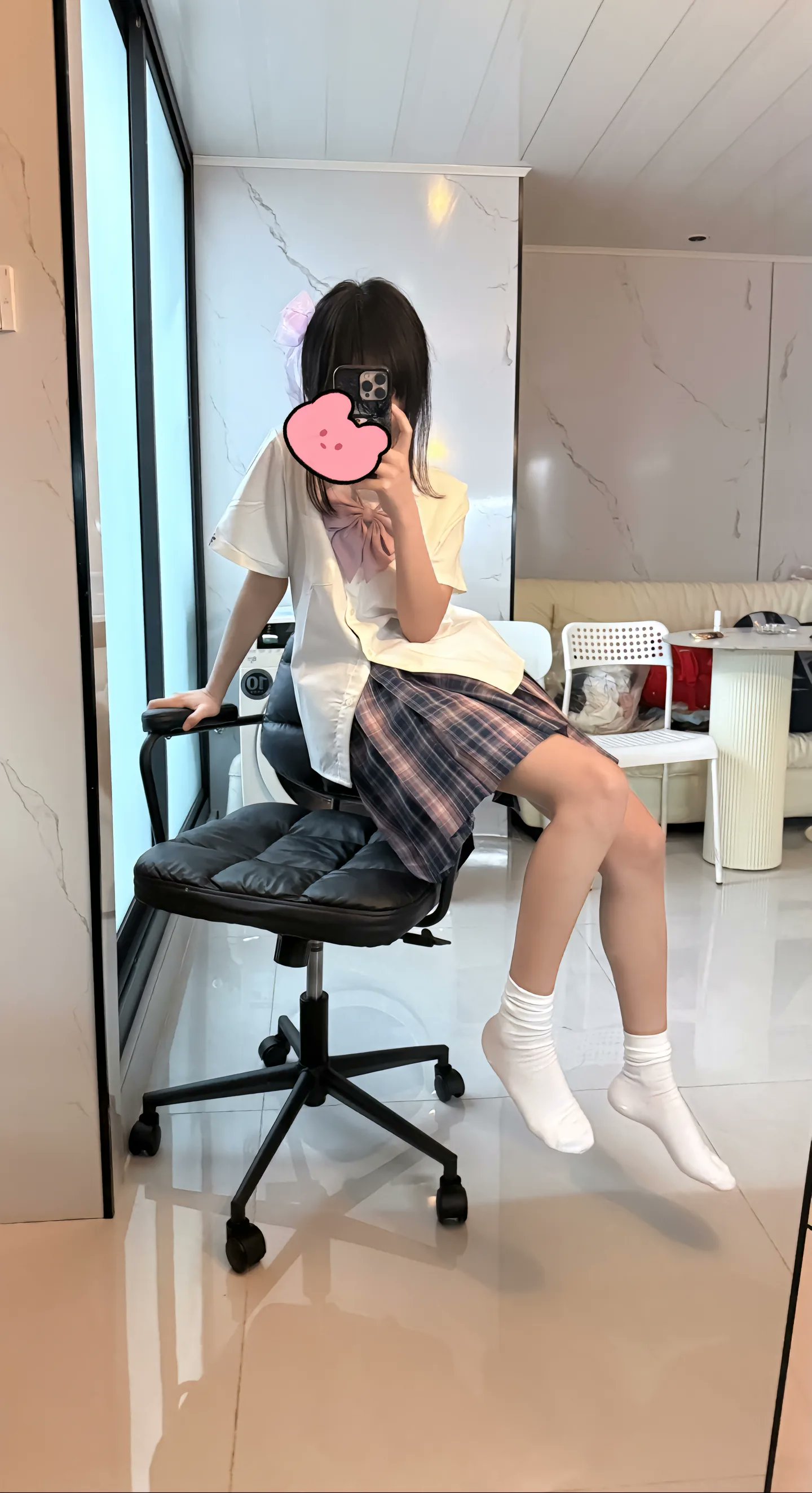 女人在一个黑色椅子的房间里拍自拍。