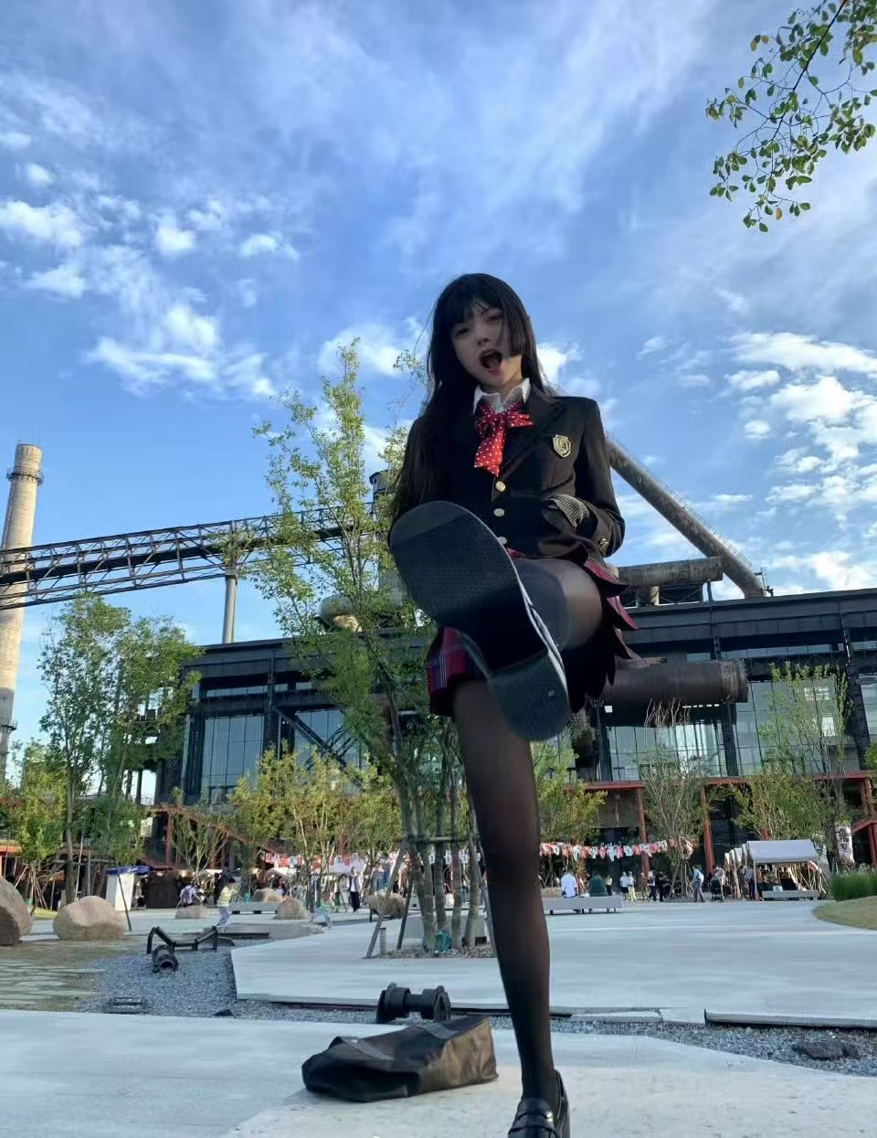 一位穿着黑色服装和红头发的女孩站在一只脚上。