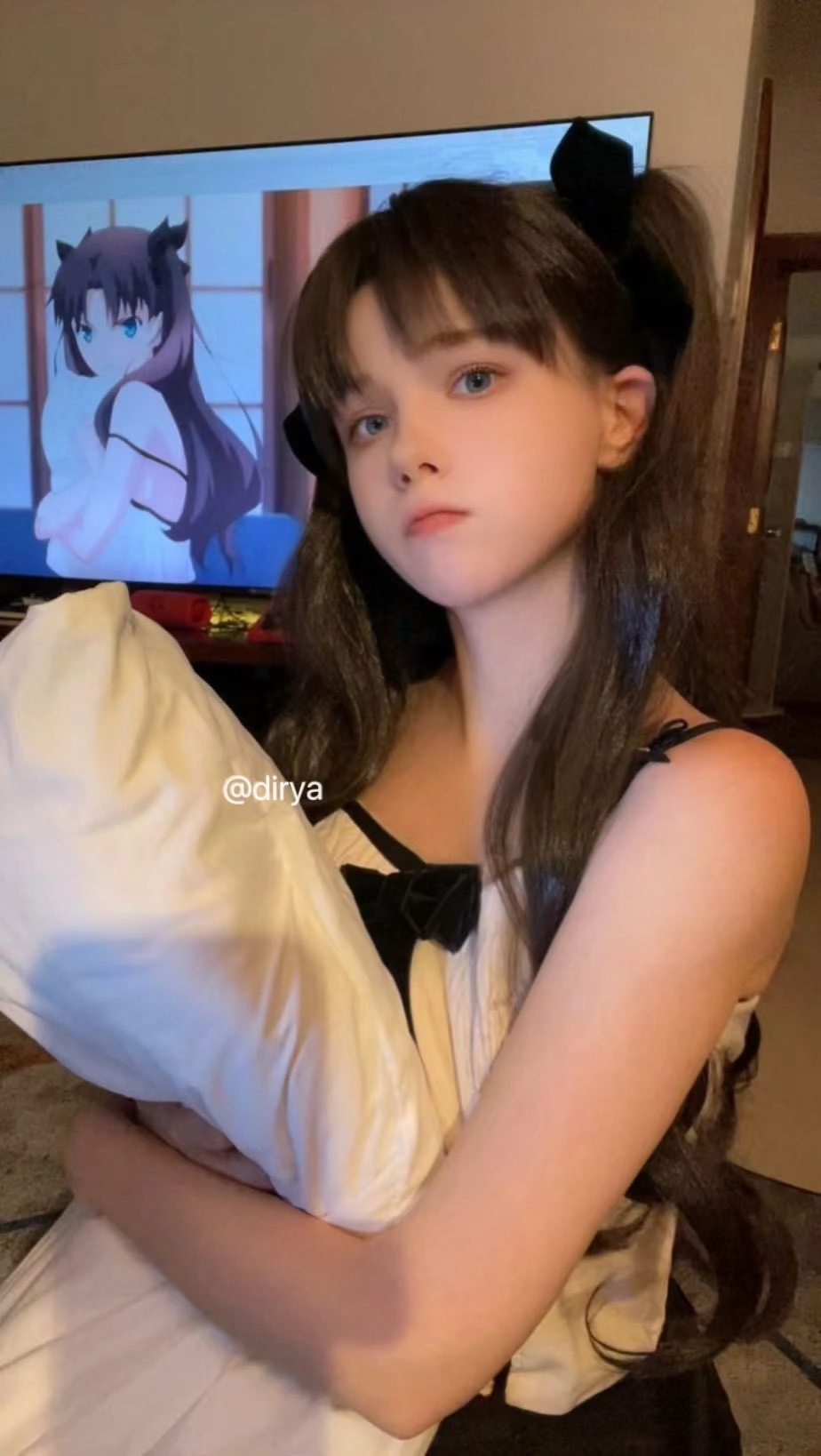 女孩抱着一个枕头,背后有电视上的卡通。