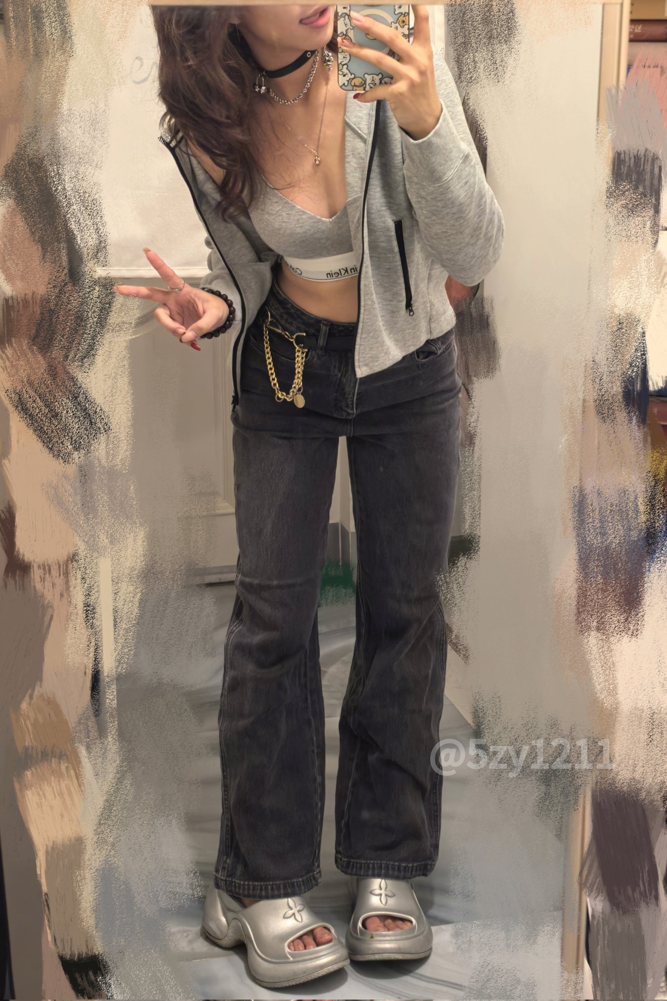 穿着灰色的胡迪和牛仔裤的女人为一张照片而立场。