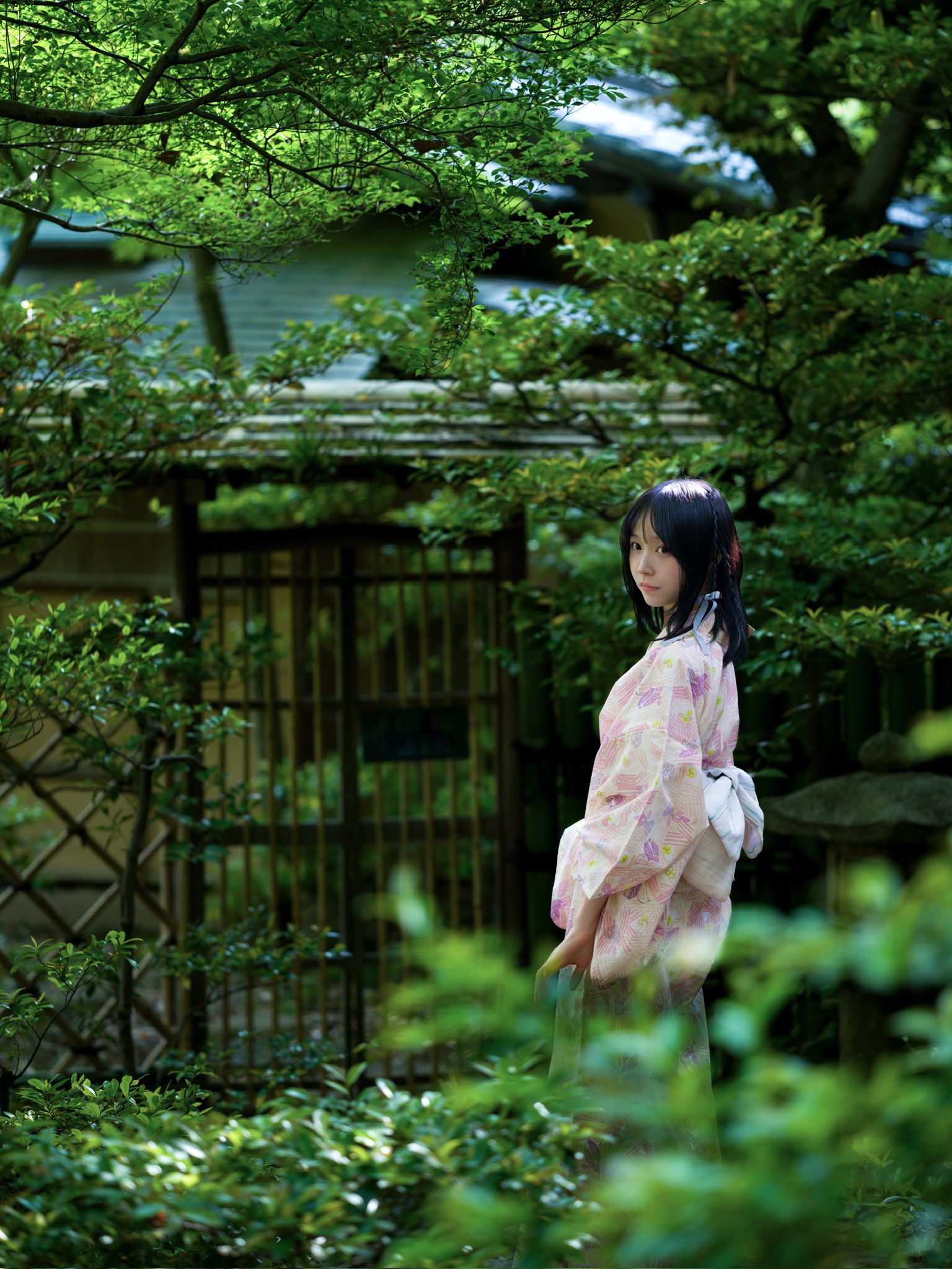 身穿吉莫诺的女人穿过一个花园。