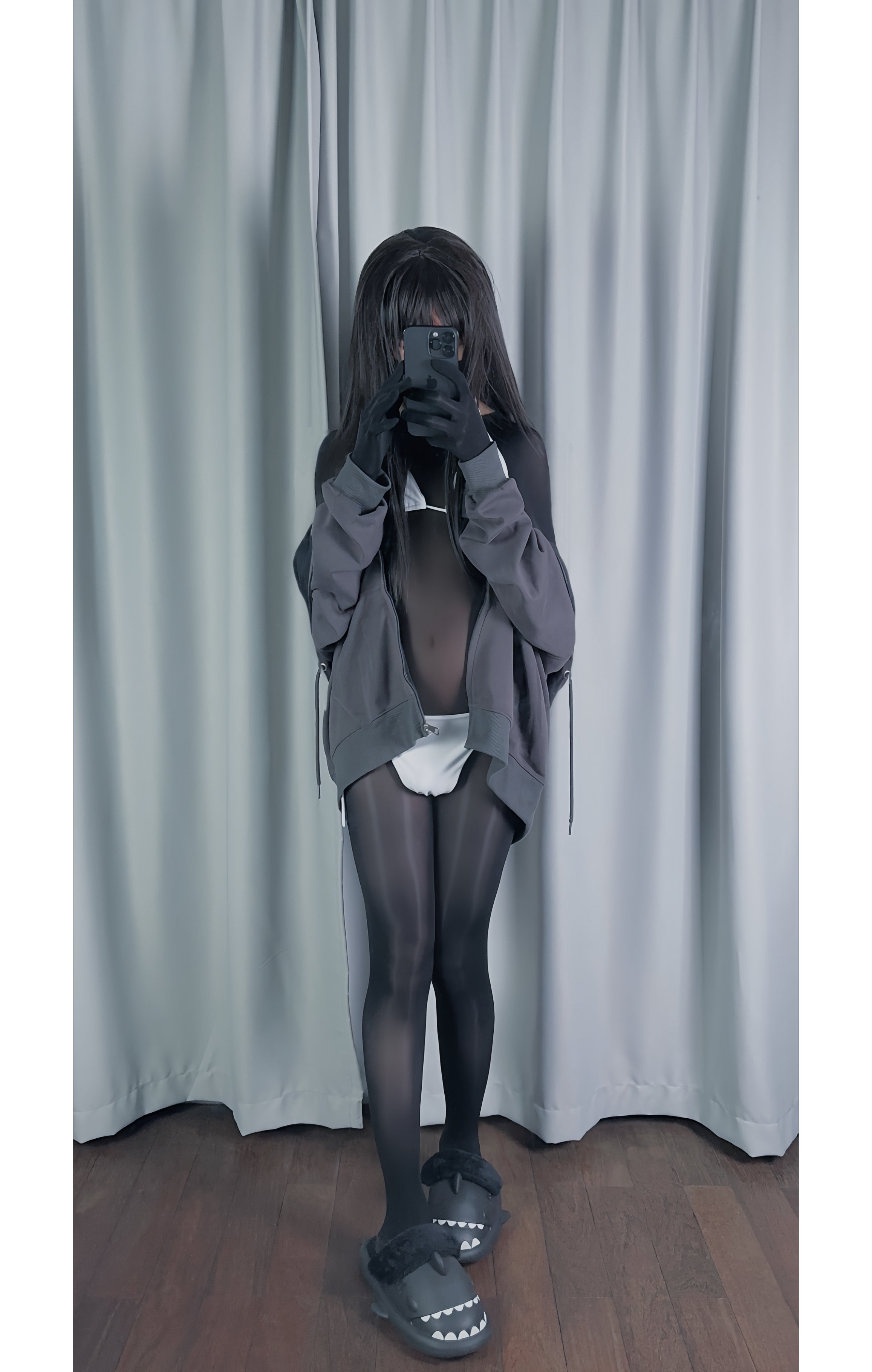 穿着灰色衬衫和黑色袜子的女人拍了一张自拍。