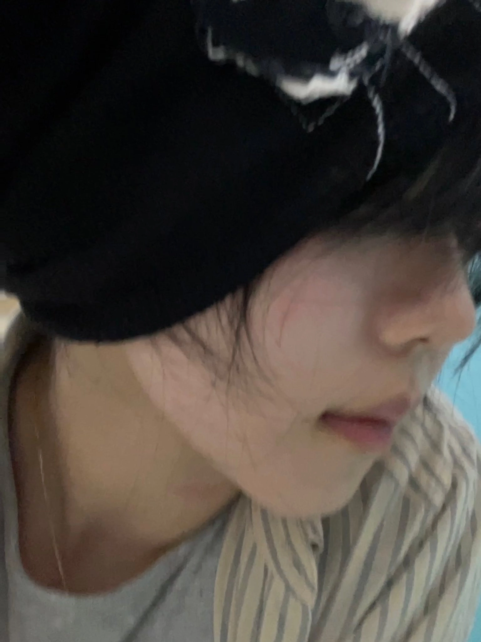 女人戴着一顶黑帽子,上面有一条白头骨。