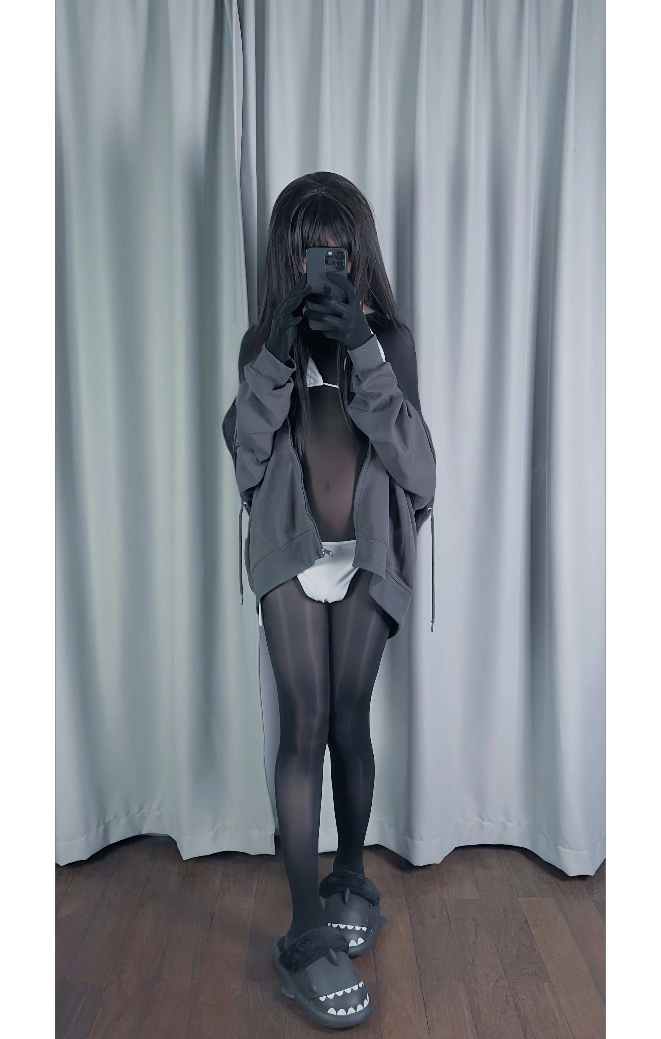 穿着灰色衬衫和黑色袜子的女人拍了一张自拍。