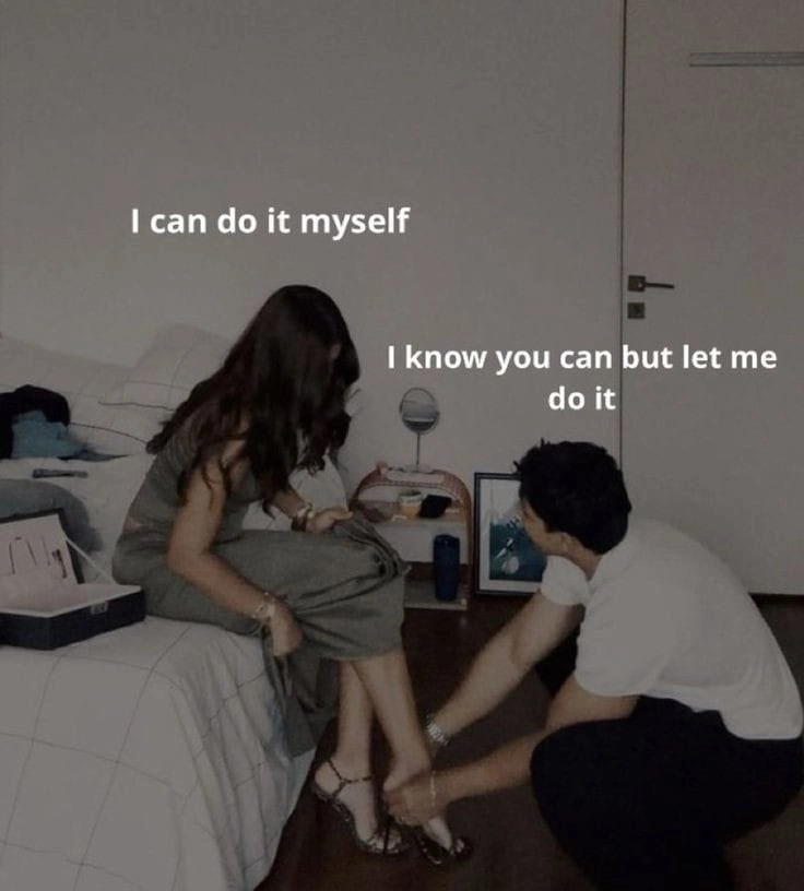 男人在弯下来绑一个女人的鞋子。