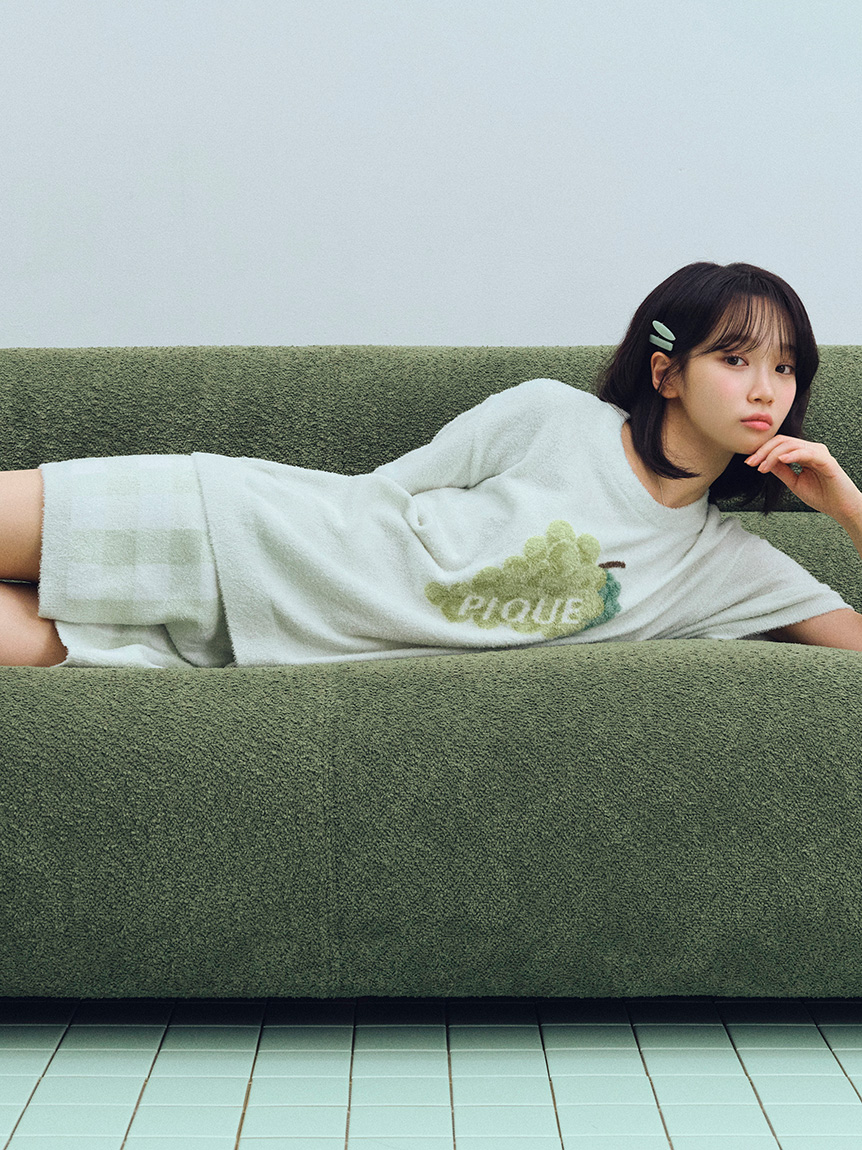 一位穿着绿色衣服的女人躺在沙发上。